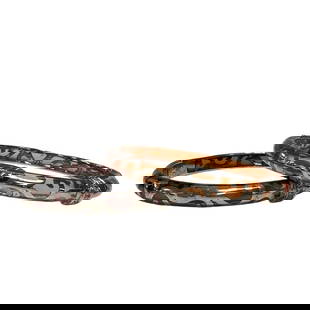 TWO ANGELIQUE DE PARIS, 'VERANDA' RESIN AND SILVER: ANGELIQUE DE PARIS, 'VERANDA' RESIN AND SILVER BANGLE BRACELETS Consisting of a hinged resin bangle surmounted with silver frame and foliate motif with 10 round mixed cut white topaz. One orange in co