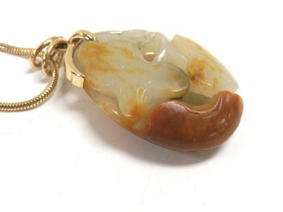 14k Yellow Gold & Carved Asian Jade Necklace: Later 20th century 14k yellow gold necklace with a large (2.4") carved white/brown Asian Jade stone. Condition is very good.