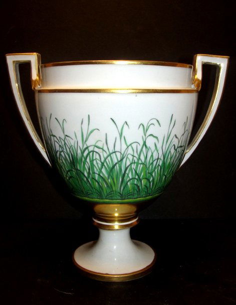 Royal Vienna Double Handle Urn Shaped Vase: With blue beehive mark and gilt trim and sprouting greenery on lower half. Condition good old restoration and inside appears repainted. H. 9'' dia.6 1/4'' handle width 9 1/4''