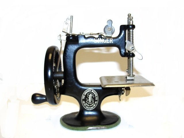 Singer Childs Toy Cast Iron Sewing Machine: Original, old Singer No. 20 child's 7 spoke hand crank sewing machine from the 1920’s. Chrome and nickel plate with black enamel paint. Original markings. 6 3/4'' x 7''