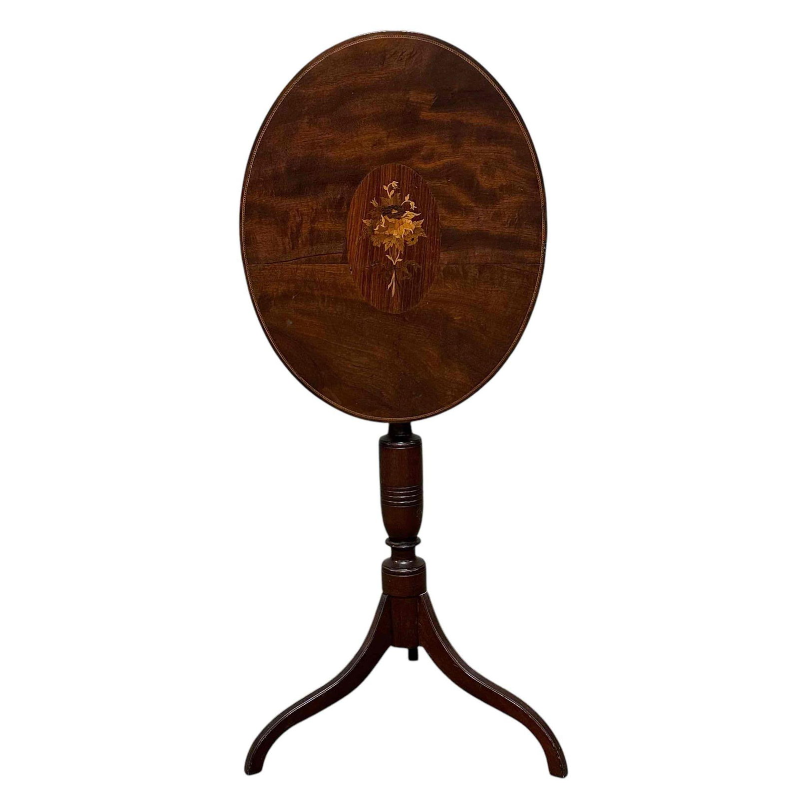19th Century American Mahogany Tilt Top Table: Oval top with flower inlay and seated on tripod base. Measuring approx 40" tall open and 28.5" h closed with a 16" x 20" top surface. Light use and wear, appears to have old repair near base as shown,