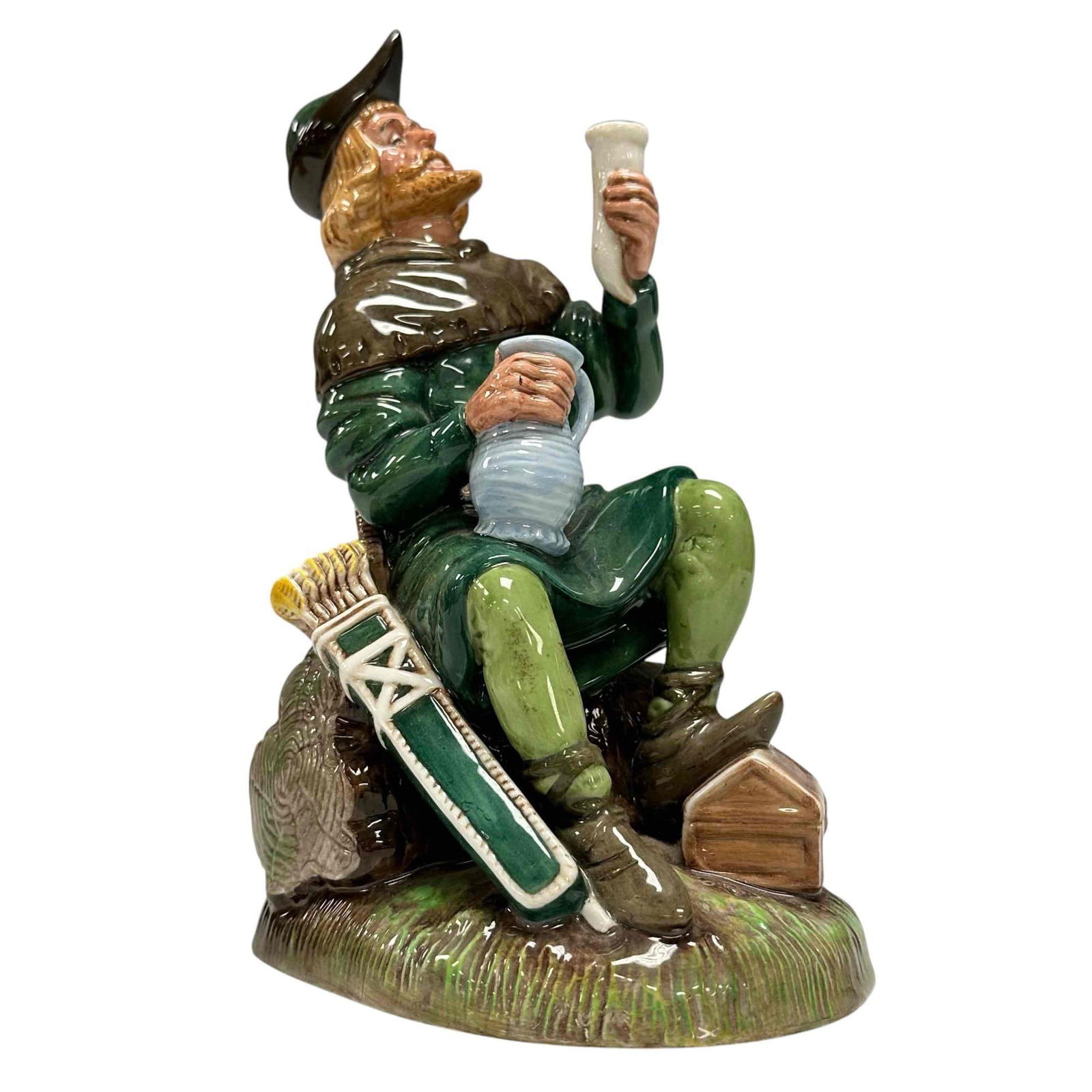 Robin Hood - Royal Doulton Figurine HN2773: Royal Doulton figurine titled Robin Hood HN2773, depicting the legendary English folk hero in traditional green attire, seated with a goblet raised and a jug in hand. William Harper measuring approx 8