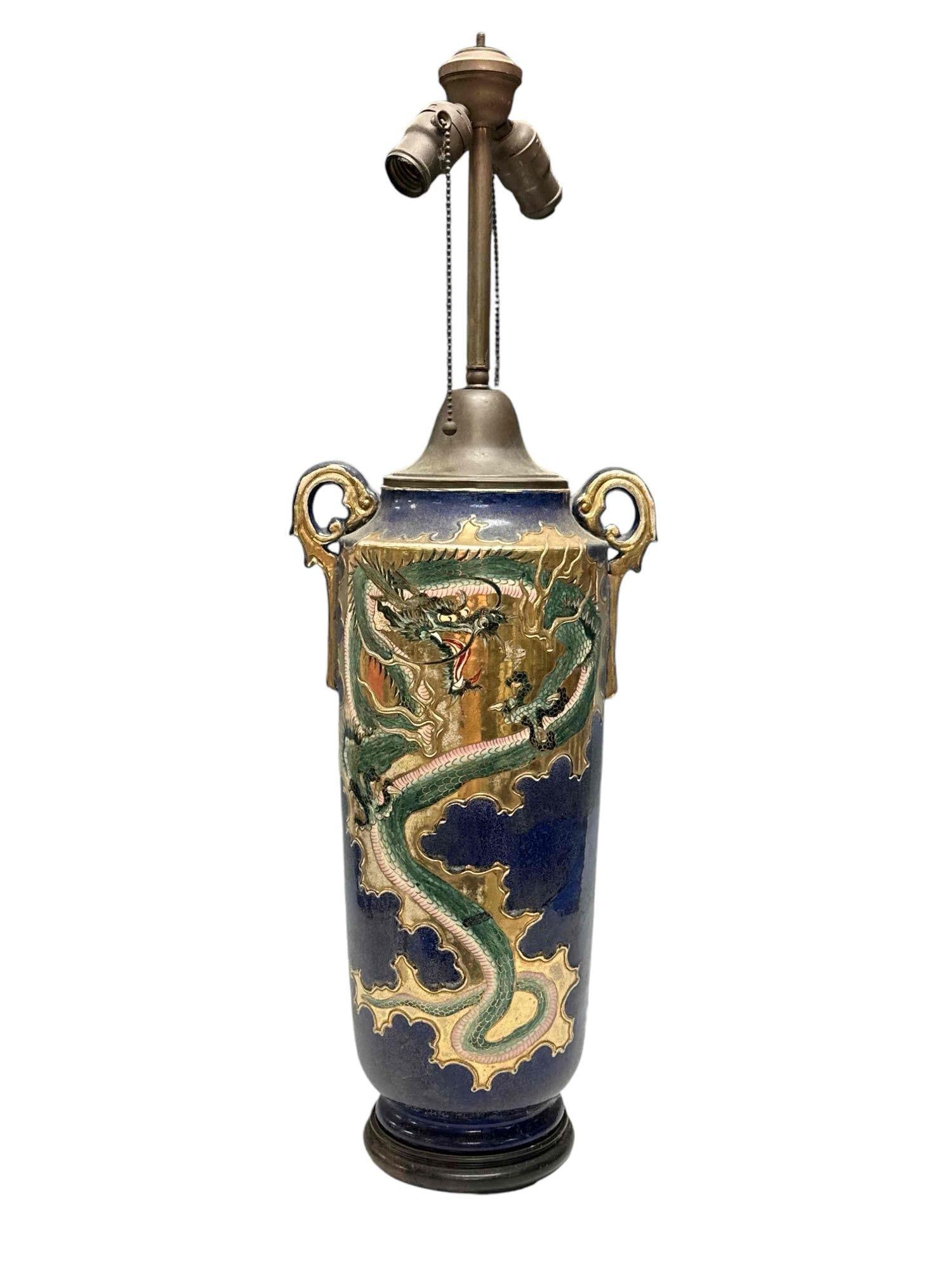 Japanese Cobalt Porcelain Lamp with Dragon Motif: 19th century Japanese porcelain lamp with dragon and gilt seated on rosewood pedestal base. Measuring approx 31" tall and porcelain measuring approx 18" h x 10" handle to handle. Light use and wear co