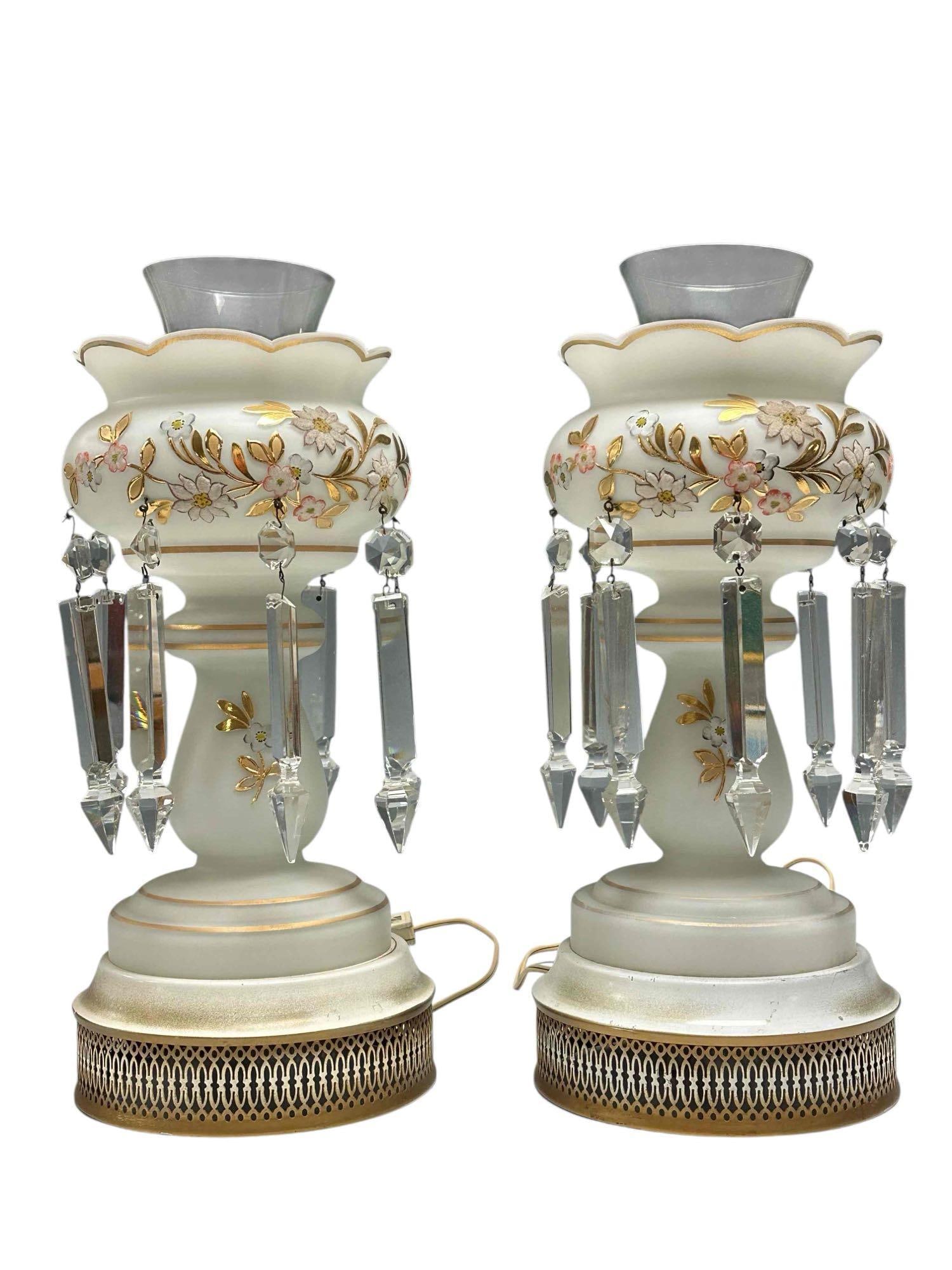 Electrified Mantle Luster with Prisms Satin White (2): Pair of satin white electrified mantle lusters with crystal prisms and hurricane glass chimneys. Each luster having 8 prisms with gold and floral trim. Measuring approx. 16" to top of chimney. In good