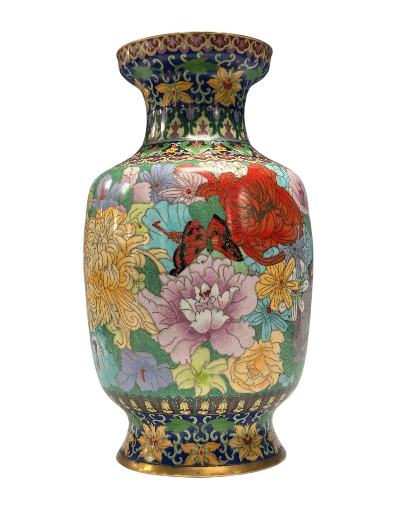 Enameled Cloisonne Butterfly Floral Floor Vase: Colorful carousel of flowers with butterflies pollinating circling this vase. Having turquoise lined interior with exposed brass top and bottom rims. Measuring approx. 15.25" tall with 5" opening. In