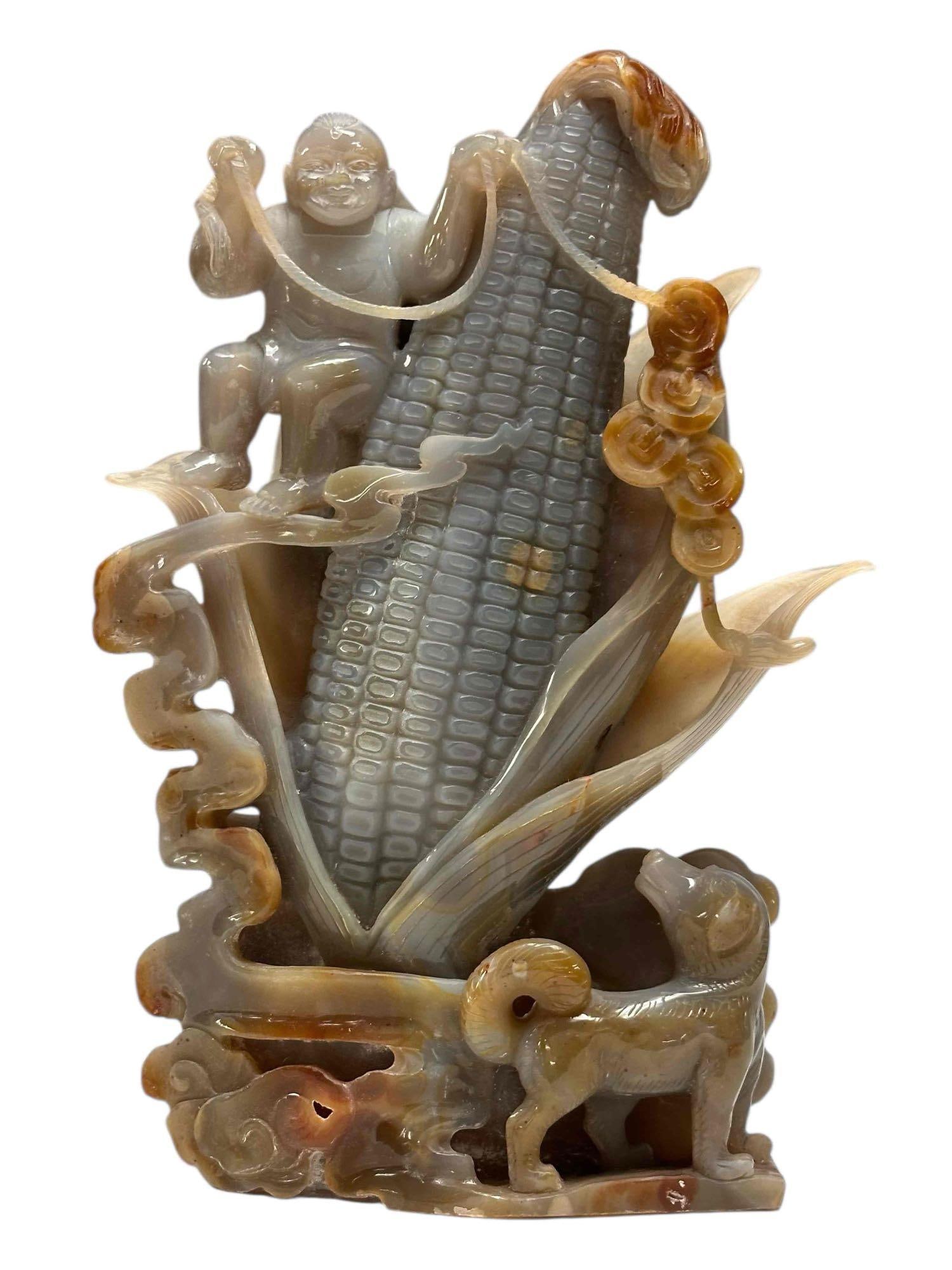 Carved Hardstone Boy on Corncob with Dog: Hardstone carving depicting large corncob with young boy swinging rope and dog looking back at him. Measuring approx. 10.75" tall by 7" wide. In good condition, see photos.