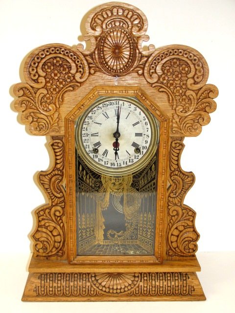 Carved Oak Shelf Clock With Alarm: Nice pressed carved oak calendar dial clock with alarm and painted door. Condition refinished and restored in working order. 25'' tall. ''All Clocks Sold As Is''