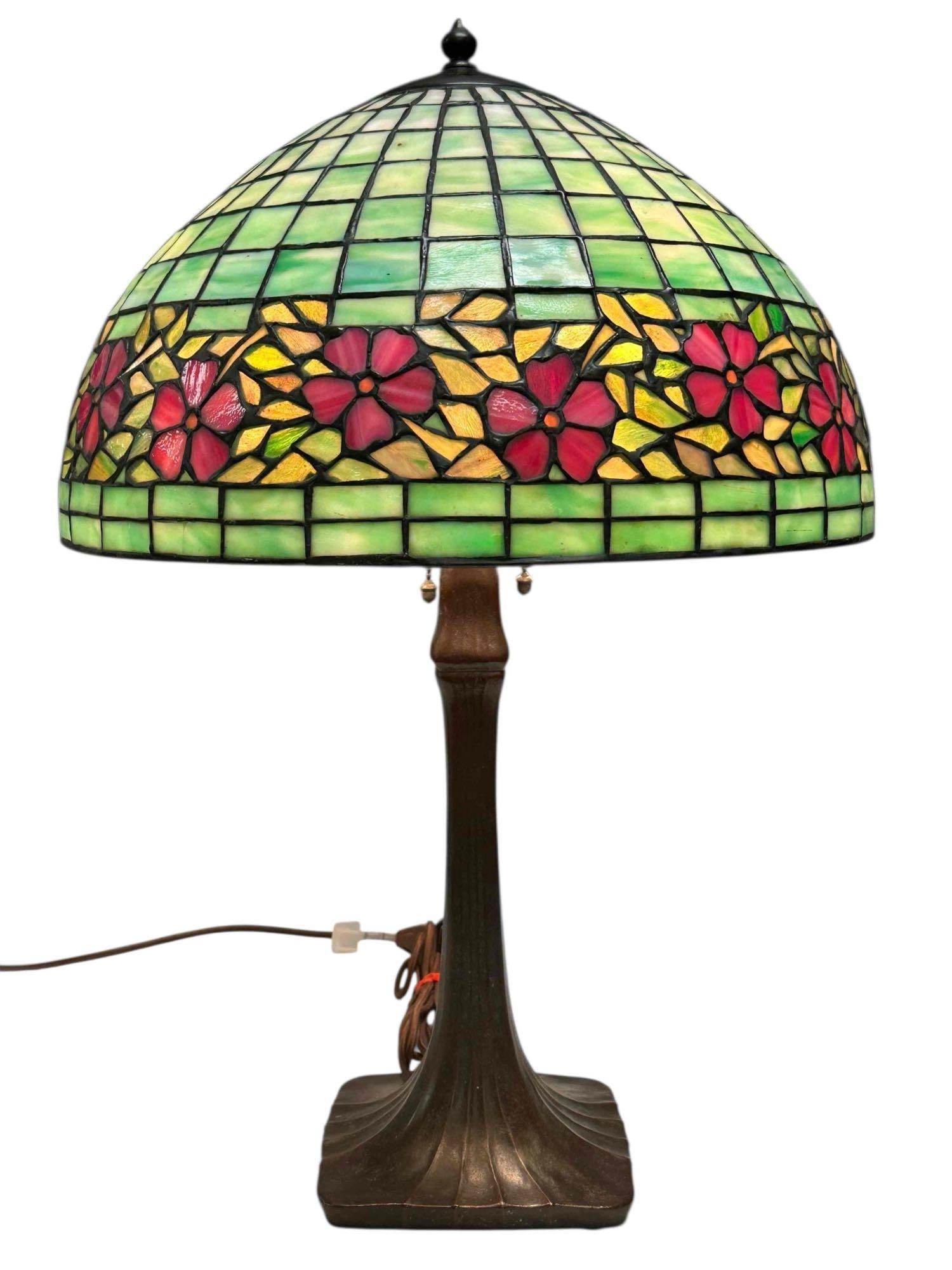 Handel Arts and Crafts Leaded Glass Bronze Table Lamp: Early 20th century, American Arts and Crafts leaded glass table lamp by Handel Lamp co in the Periwinkle / Cherry Blossom pattern, pink floral border and seated on bronze base. Marked as shown. Measur