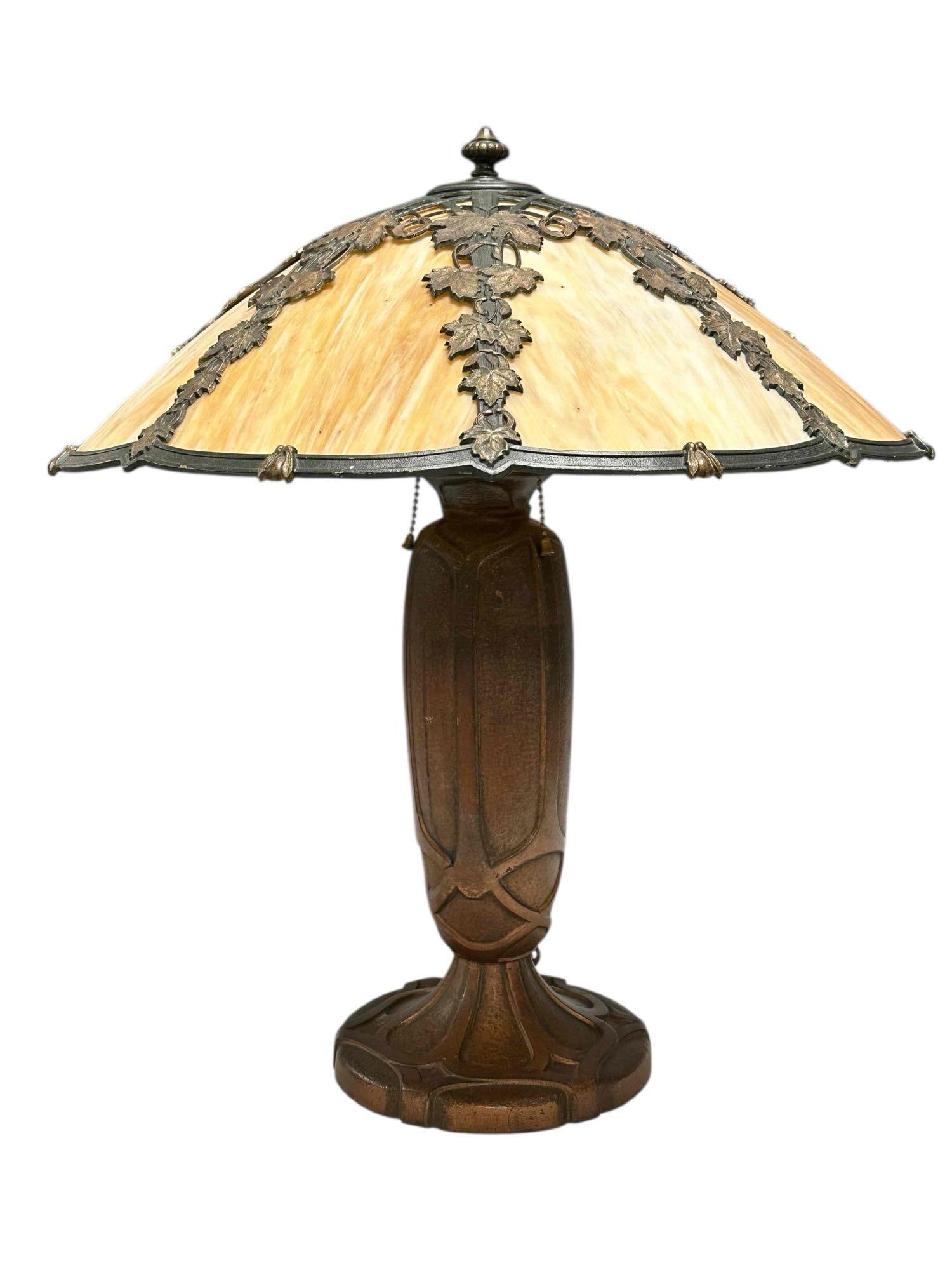 Bradley Hubbard Art Nouveau Lamp with Leaf Overlay: Early American, Bradley and Hubbard table lamp with slag and leaf overlay and seated on three socket ornate bronzed metal art nouveau base. Measuring approx 22" h x 19" x 19" diameter shade Light use