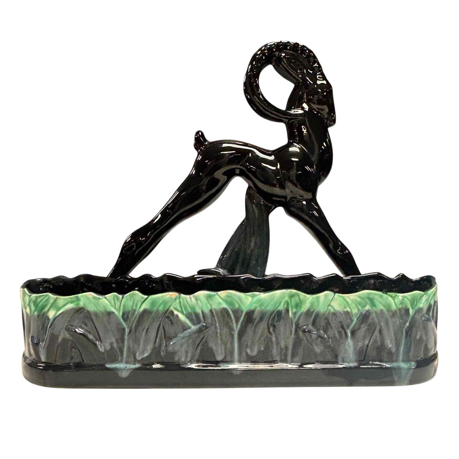 Royal Haeger Mid Century Modern Ceramic Ram Planter: A vintage glazed ceramic figural ram/gazelle planter. This piece is glossy black with green and gray accents. measuring approx. 14" tall by 17.5" wide by 5.5" thick. In good condition with a few rim e