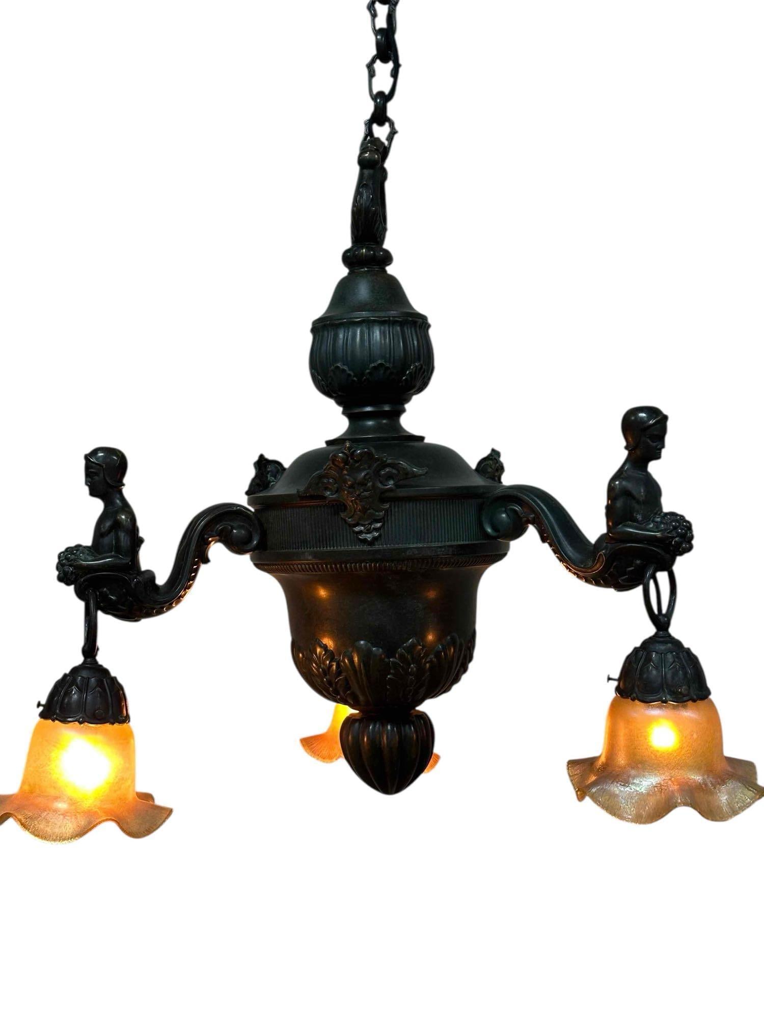 Renaissance Revival Style Three Light Hanging Light Fixture: Another great hanging ceiling light fixture / chandelier with three hanging lights fitted with Quezal art glass shades. Ornate patinated bronze finished frame having figural arms and grotesque feature