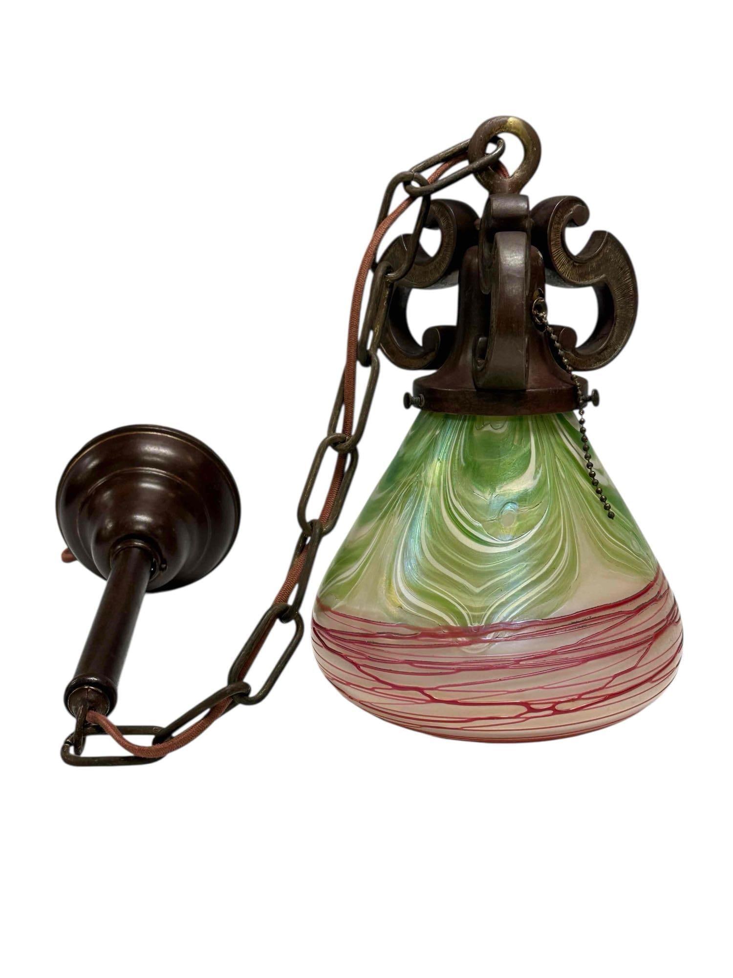 Bronze Hanging Light Fixture with Art Glass Shade: Arts and Crafts style hanging pendant light fixture with pulled feather and thread Art Glass shade. Measuring approx. 12" x 8" just the fixture and overall with chain and ceiling cap measuring approx