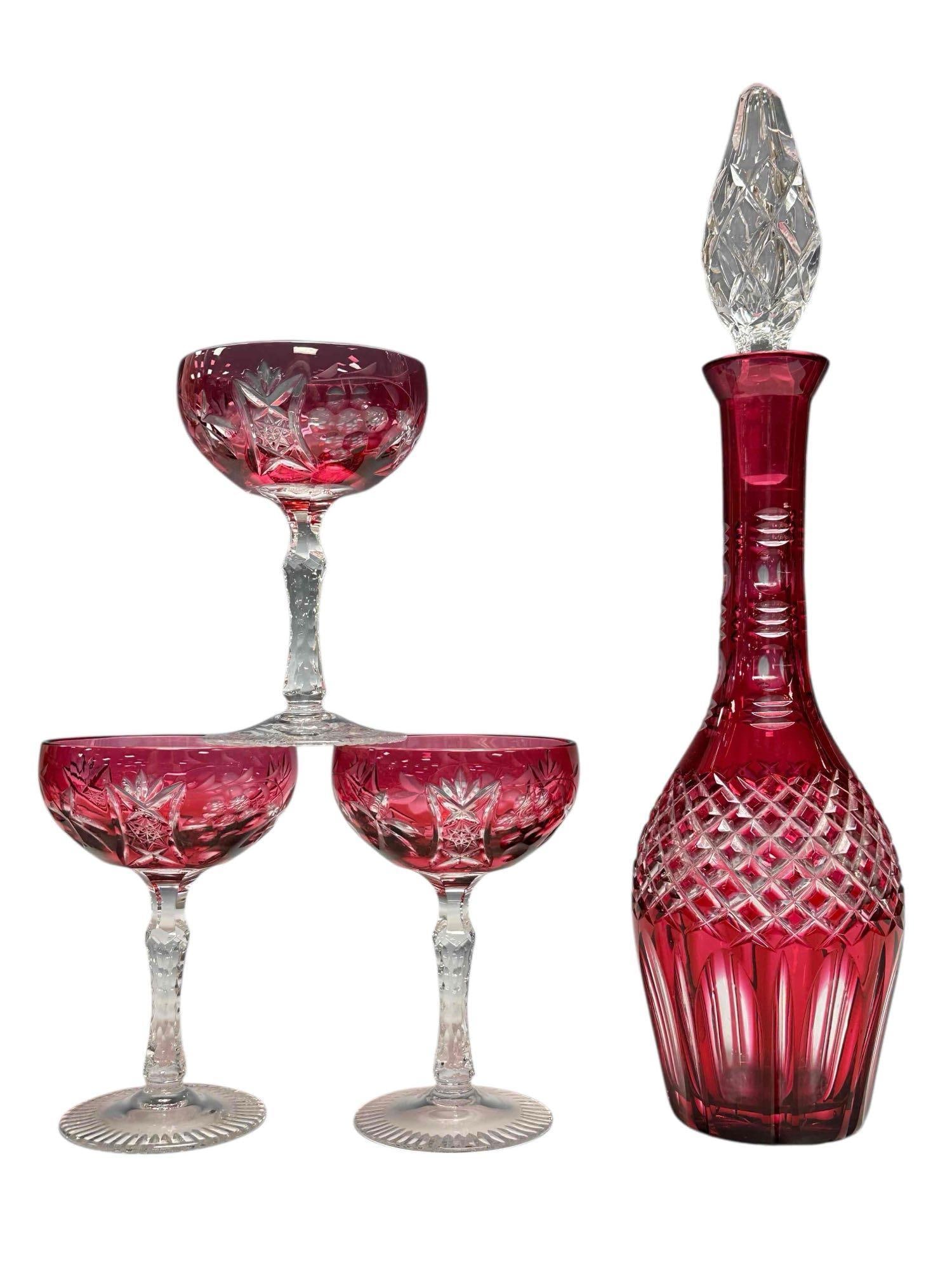 Bohemian Cranberry Cut to Clear Crystal Decanter Set (4): Four piece Bohemian cranberry cut to clear crystal decanter with three hock wine glass set. Decanter measuring approx. 16.25" tall glasses 5.75" tall. In good condition with one chip to stopper, see p