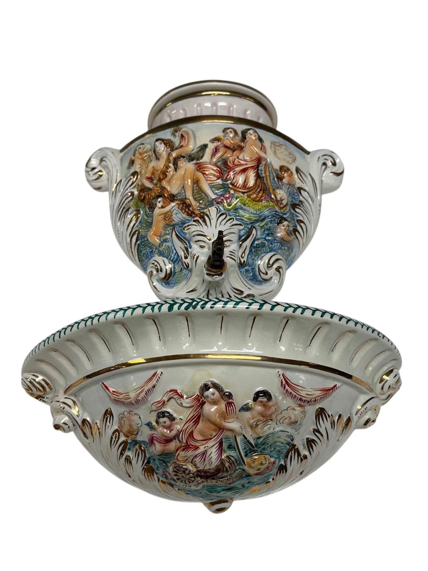 Capodimonte Italian Porcelain Water Fountain Urn Water Pocket: Vintage Capodimonte Italy porcelain figural wall fountain urn. Upper porcelain water lidded reservoir with spout flowing to separate wall pocket. Measuring approx. 14.5" tall reservoir with 14" wide w