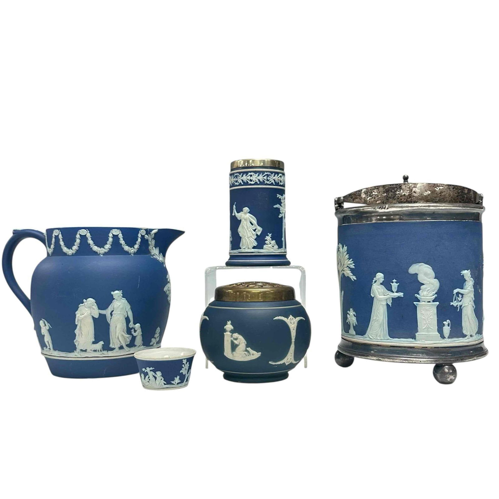 Wedgwood Blue Jasperware Collection (5): Wedgwood blue jasperware Including; silver-plated biscuit barrel on there ball feet 7.5" tall, stoneware pitcher or water jug 5.75" tall, flower frog with brass lid 3.5" tall , traditional spill vase
