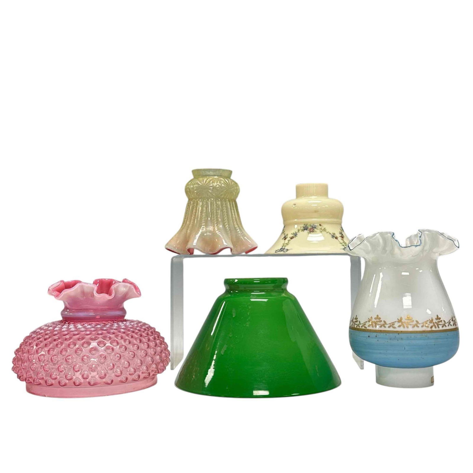 Fenton and Art Glass Lamp Shade Grouping (5): Includes; hand painted opaline ruffled rim blue band and gold foliage 7" tall, opalescent cranberry to yellow pond lily design likely Fenton 4.5" tall, green cased cone pendant white interior 4.75" ta