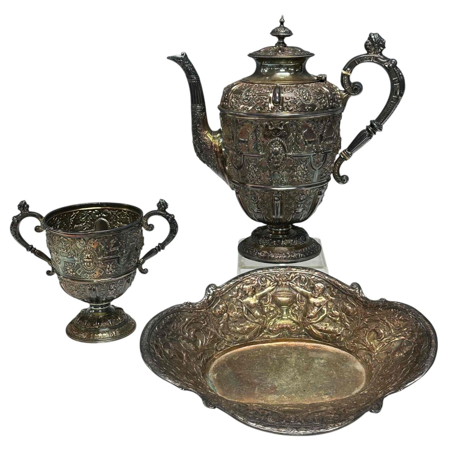 19th Century Heavy Repousse Teapot with Serving Dishes (3): Highly detailed raised relief Victorian late Renaissance era Cellini style silver plated pedestal teapot 10.5" tall and double handled urn style depository bin 6.75" tall . Both having fine quality em