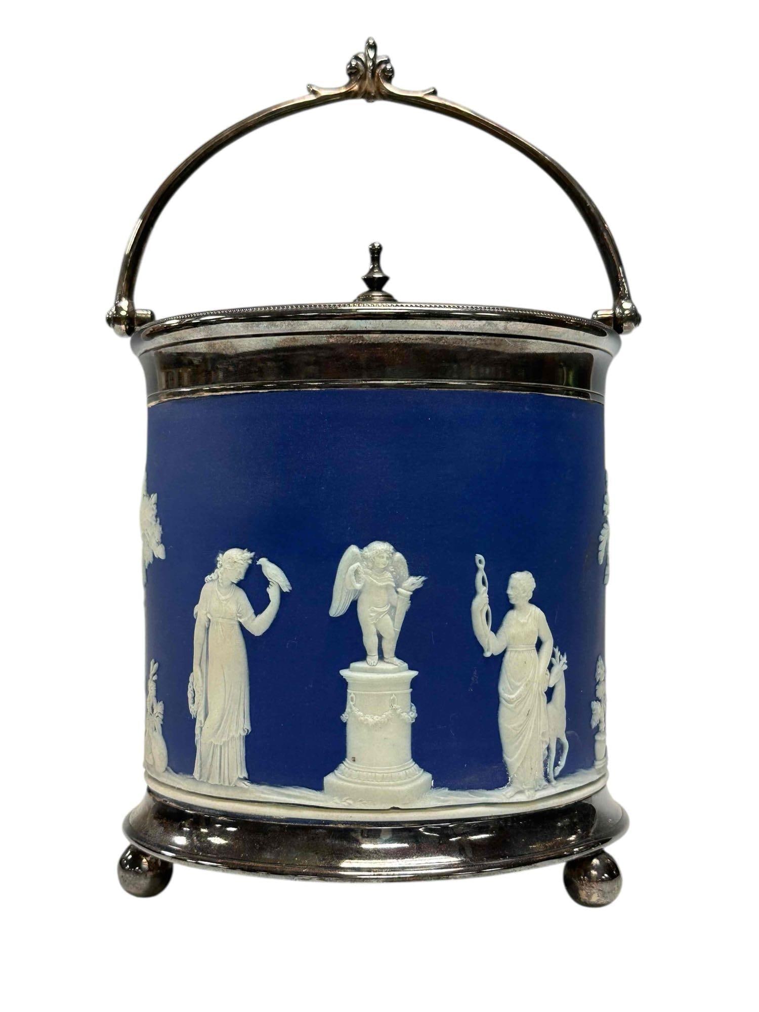 Wedgwood Blue Jasperware Biscuit Barrel: Late 19th century Wedgwood blue jasperware biscuit barrel. Having silver plated frame and lid on three ball feet. Measuring approx. 7.5" tall to top of finial. In good age appropriate condition with n
