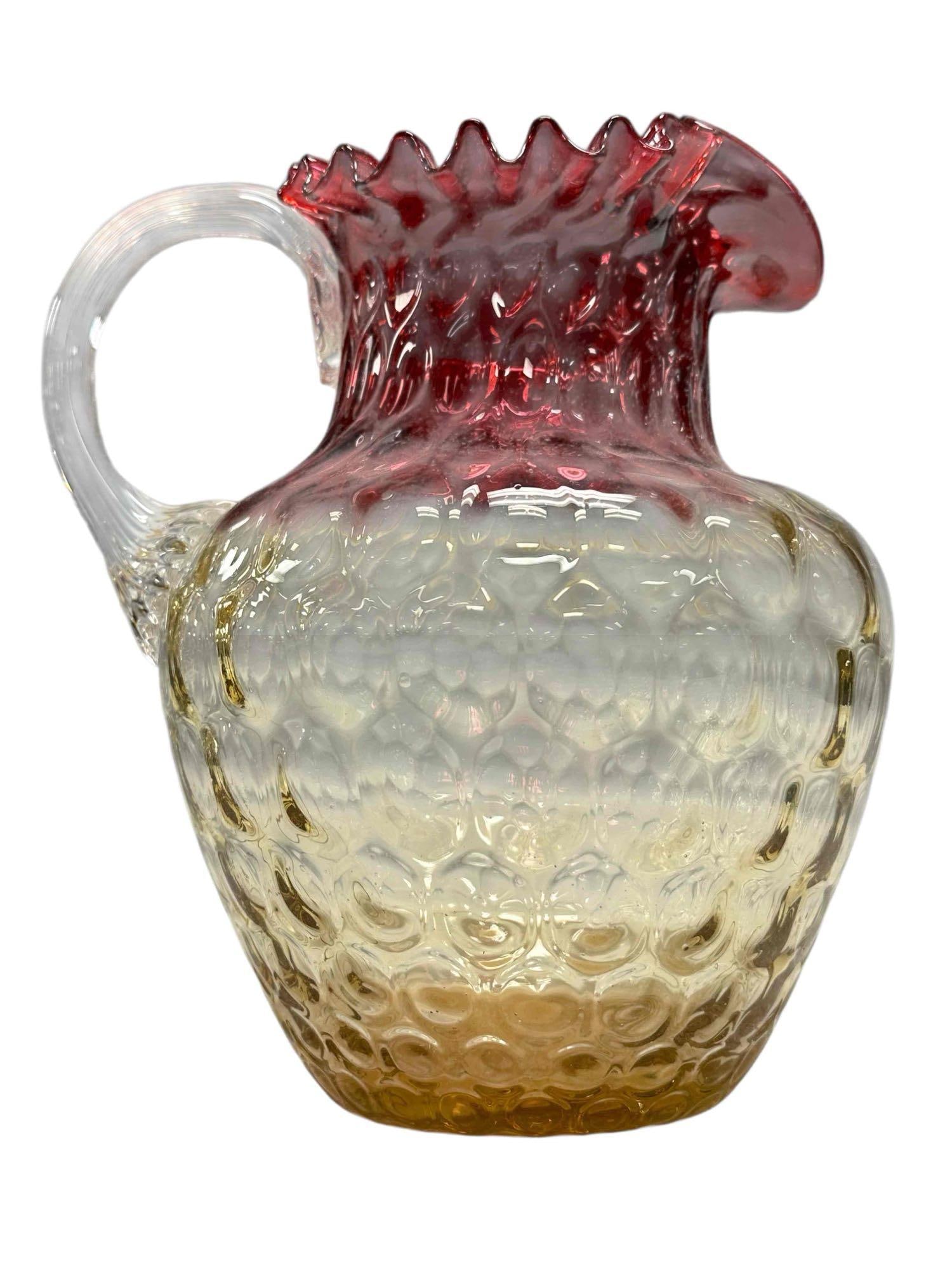 Circa 1880 Amberina Inverted Thumbprint Art Glass Pitcher: Late 19th century Amberina Coin Dot art glass pitcher. Having gradient ruby red ruffled top to a warm amber/yellow base with applied reeded handle. Measuring approx. 8.5" tall. In good condition with