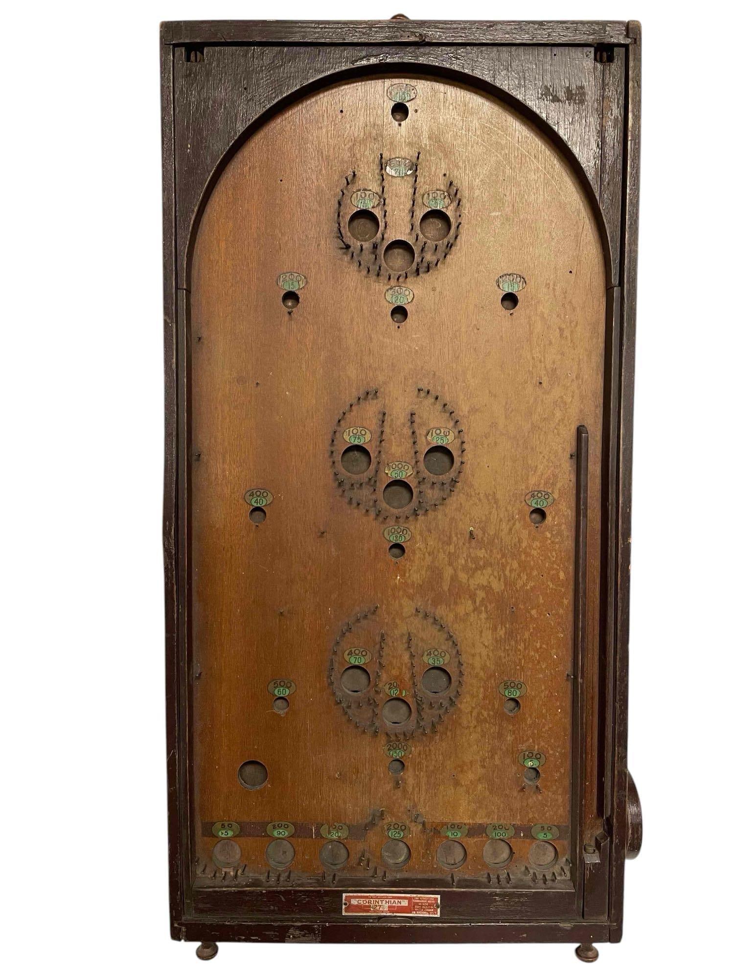 Early Bagatelle Game - Corinthian 27 1/2: The "Corinthian" 27 1/2 states it is a "recognized tournament board". This piece is in fair condition. The box is sturdy and feels fine to move around. The marble feeding device may function with the