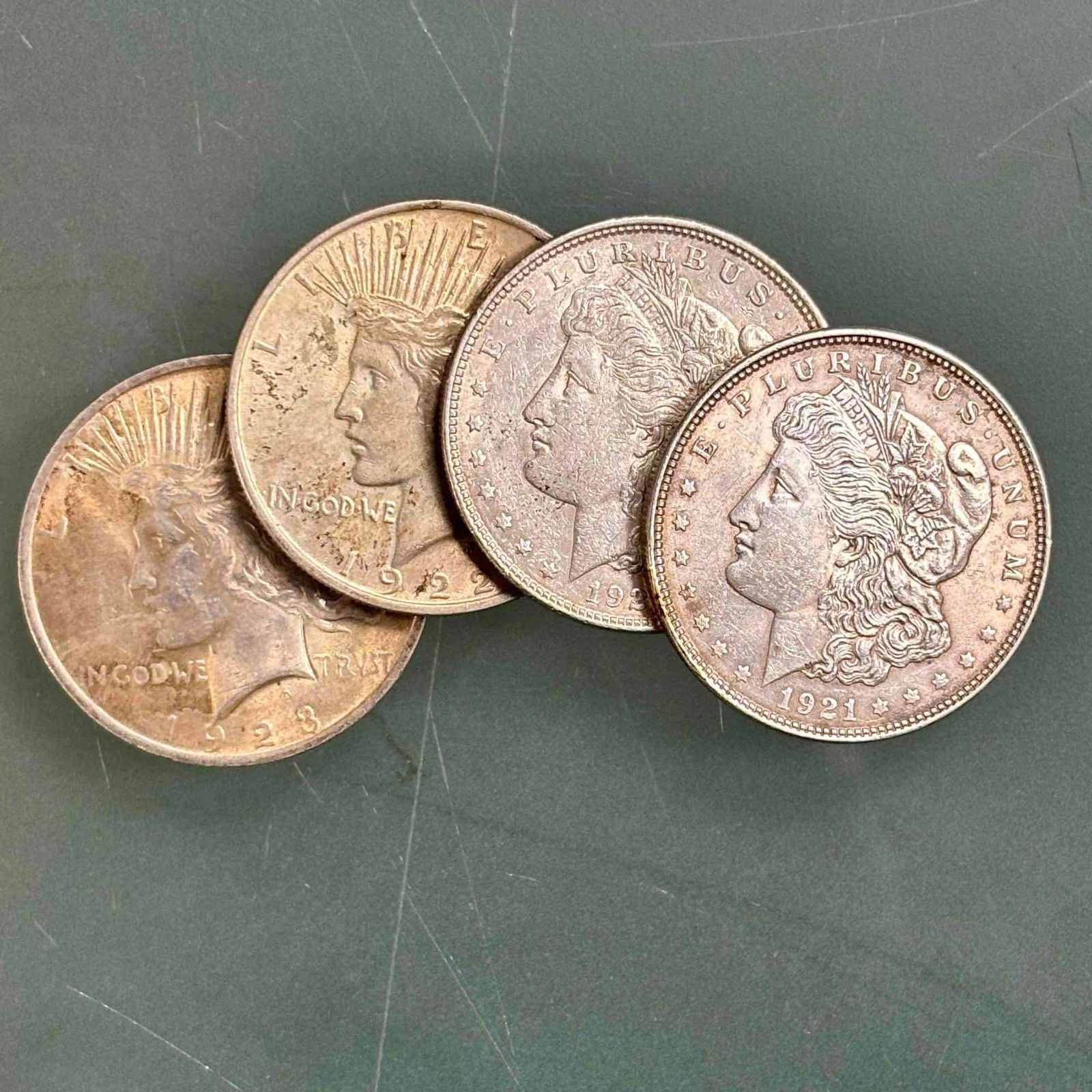 Morgan & Peace Silver Dollars 90% Silver (4): Early 20th century 90% silver including; two 1921 Morgan silver dollars, 1922 Peace silver dollar and 1923 Peace silver dollar. In age appropriate condition, see photos.