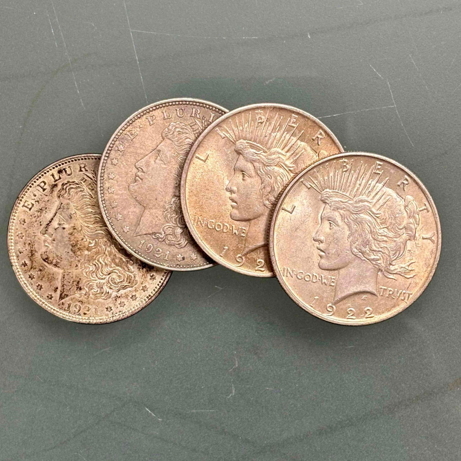 Morgan & Peace Silver Dollars 90% Silver (4): Early 20th century 90% silver including; two 1921 Morgan silver dollars, 1922 Peace silver dollar and 1923 Peace silver dollar. In age appropriate condition, see photos.