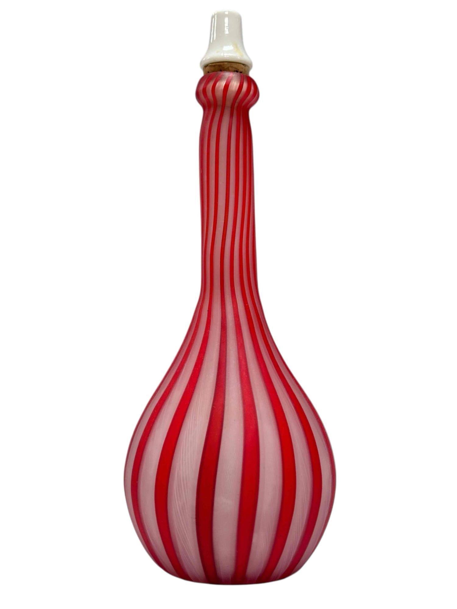 Red and White Venetian Glass Barber Bottle: Candy cane opalescent red and white glass barbers bottle with white porcelain cork stopper. Measuring approx. 10" tall to top of stopper. In good condition with no breaks or chips noted, see photos.