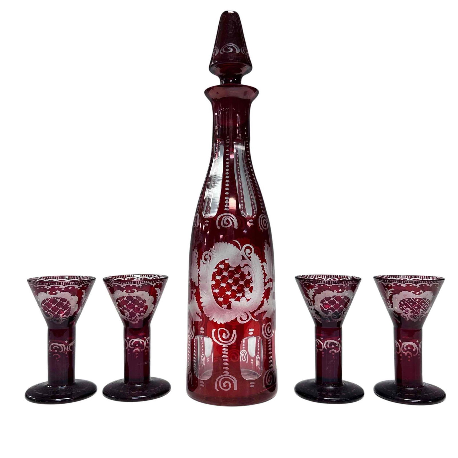 Bohemian Ruby Red Cut to Clear Decanter and Cordials (6): Bohemian ruby red cut to clear decanter with stopper and five wide stemmed cordial glasses. Measuring approx. 13" tall decanter 3.75" tall cordials. In good condition with no breaks noted, see photos.