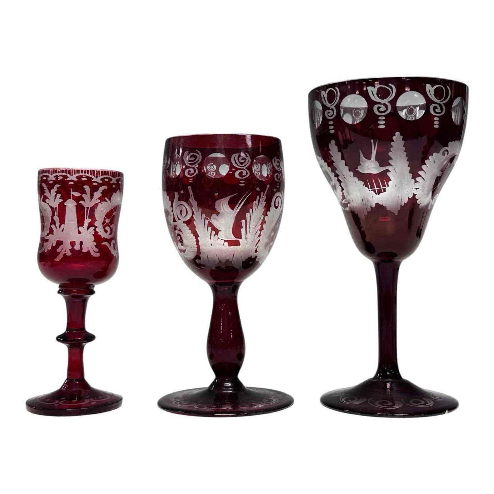 Ruby Red Cut to Clear Bohemian Stemware (12): Twelve piece Bohemian ruby cut to clear stemware with deer, birds and landscape scene. Including; 4 cordial glasses 4.25" tall, 4 champagne glasses 5" tall and 4 wine glasses 5.75" tall. In good age a