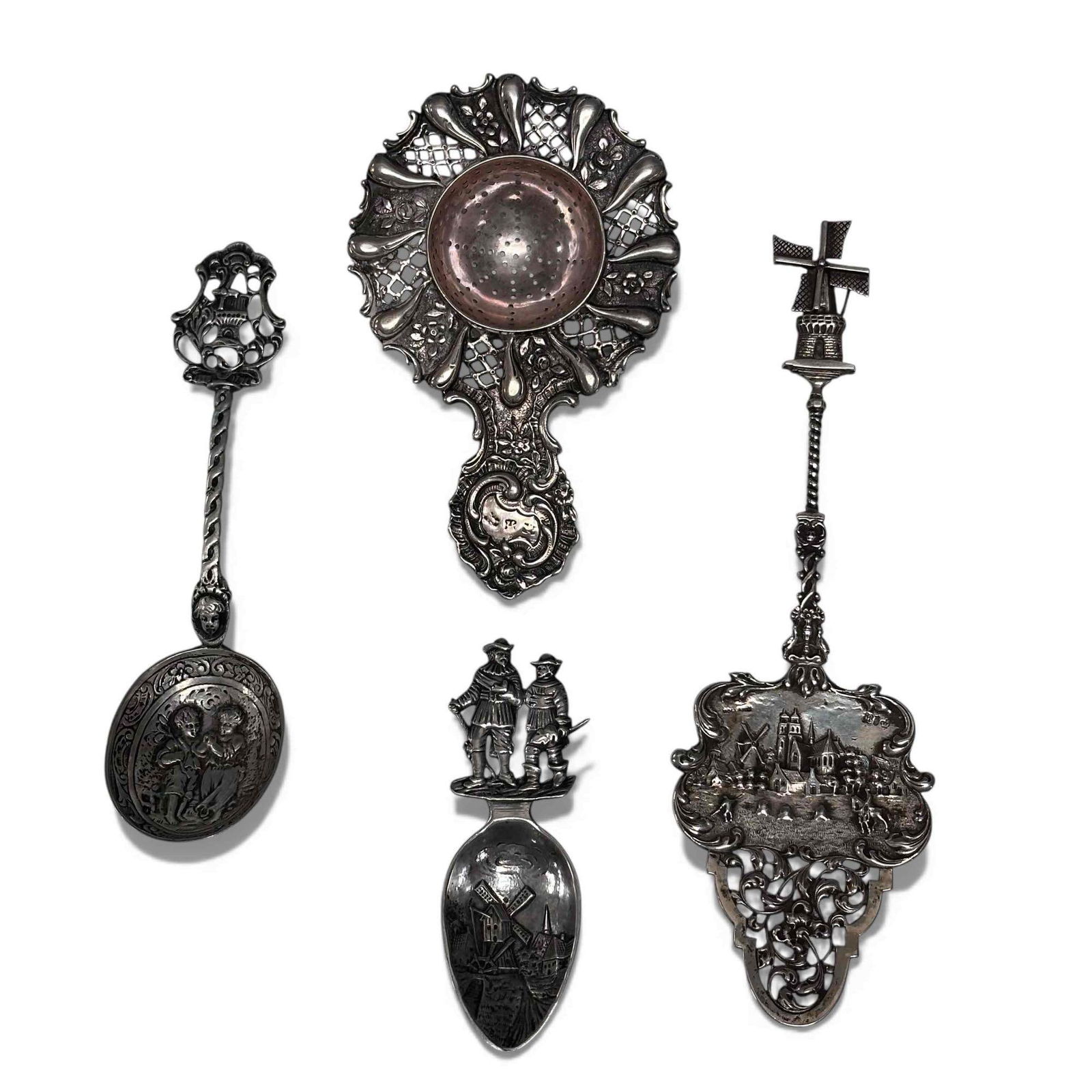 Holland Souvenir Utensils Tea Strainer Group (4): Holland ornate windmill embossed figural pie server 7.25" long, art nouveau tea strainer 4.75" long, twisted body raised relief figural souvenir spoon 5.75" long and Dutch souvenir caddy spoon with tr