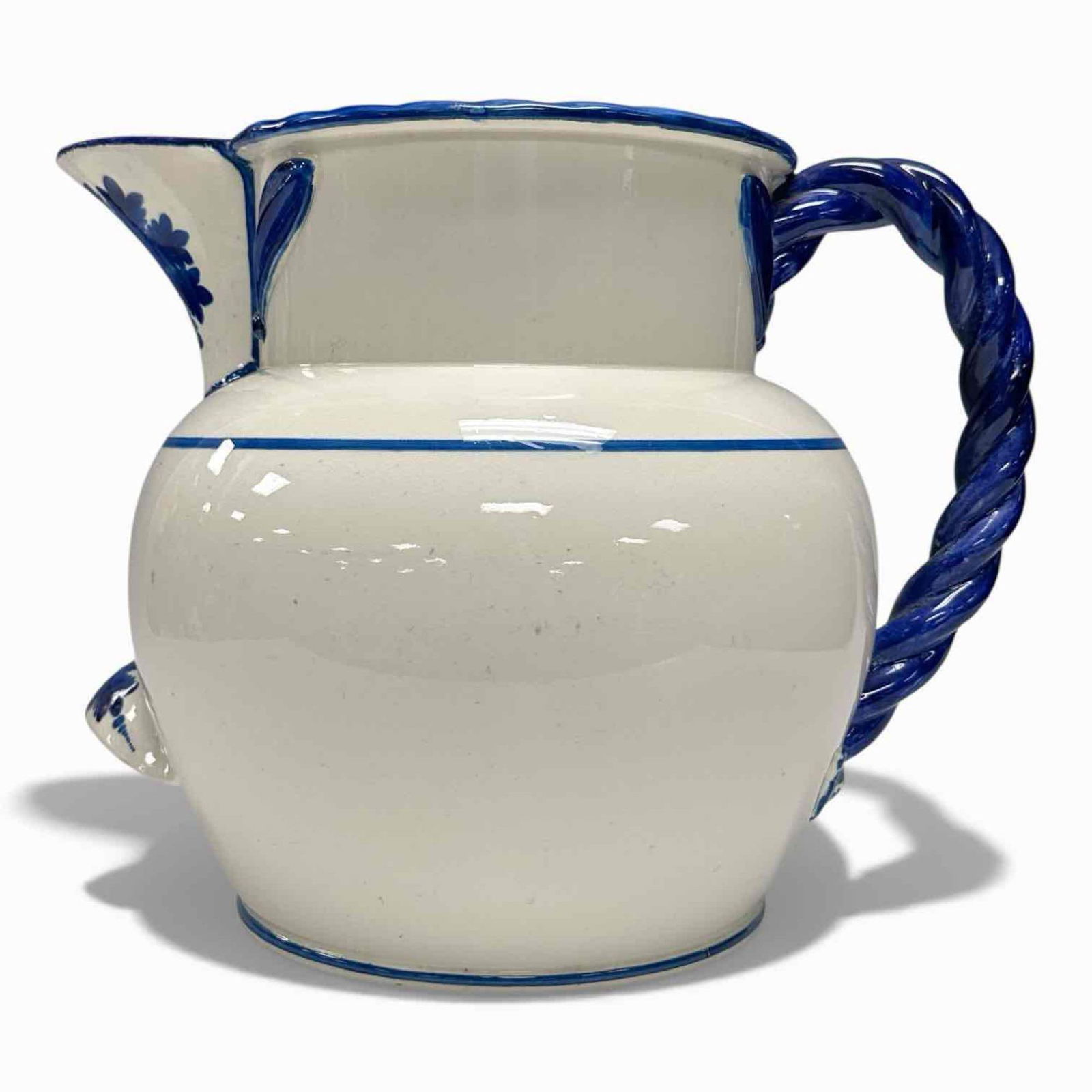 18th C. Davenport Spiced Wine Pitcher: Blue and white ceramic pitcher from Davenport. White glazed body with hand-painted blue floral leaf-like decorations, similar to Portuguese's pottery. Twisted blue handle and a small rest near the bas