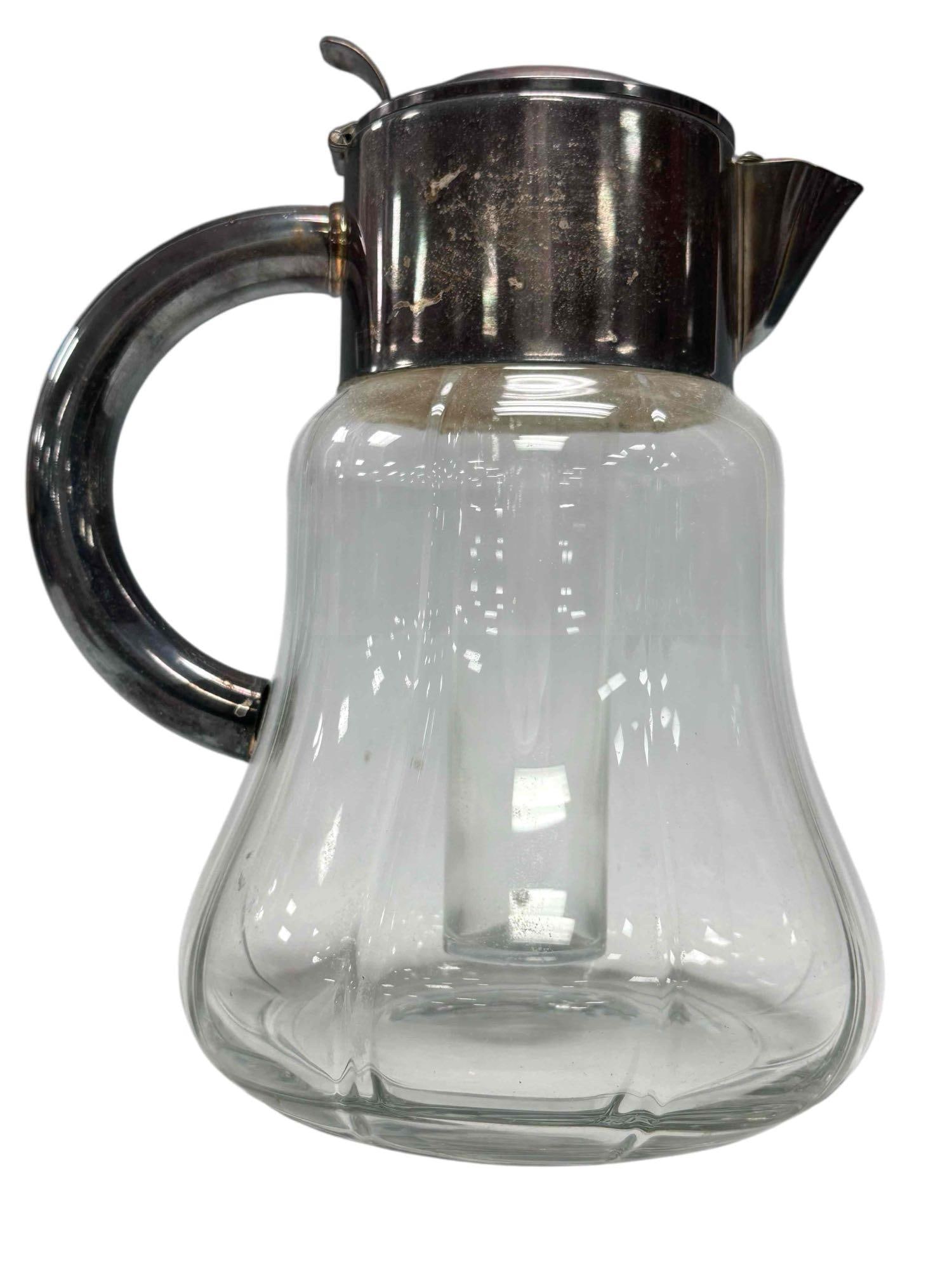 Silver Plate German Crystal Water Pitcher with Ice Insert: Late 19th early 20th century thick crystal decanter with glass insert ice cube tube. Crystal bell shaped body with silver plated lid and handle. Stamped on neck D.R.G.M.. Measuring approx. 10.75". In