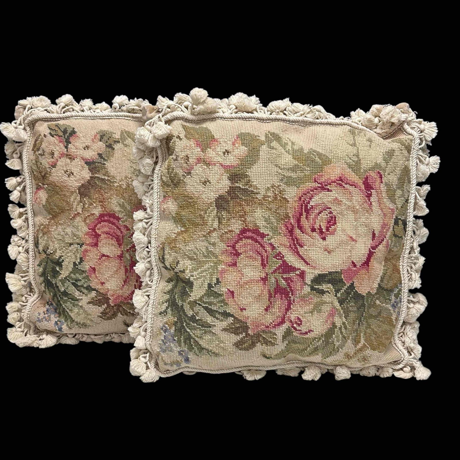 Needlepoint Wool Floral Rose Bouquet Throw Pillows with Tassels (2): Pair of vintage beige needlepoint throw pillows with rose pattern decor and bell tassels. Measuring approx. 18" by 18" wide. In good condition, see photos.