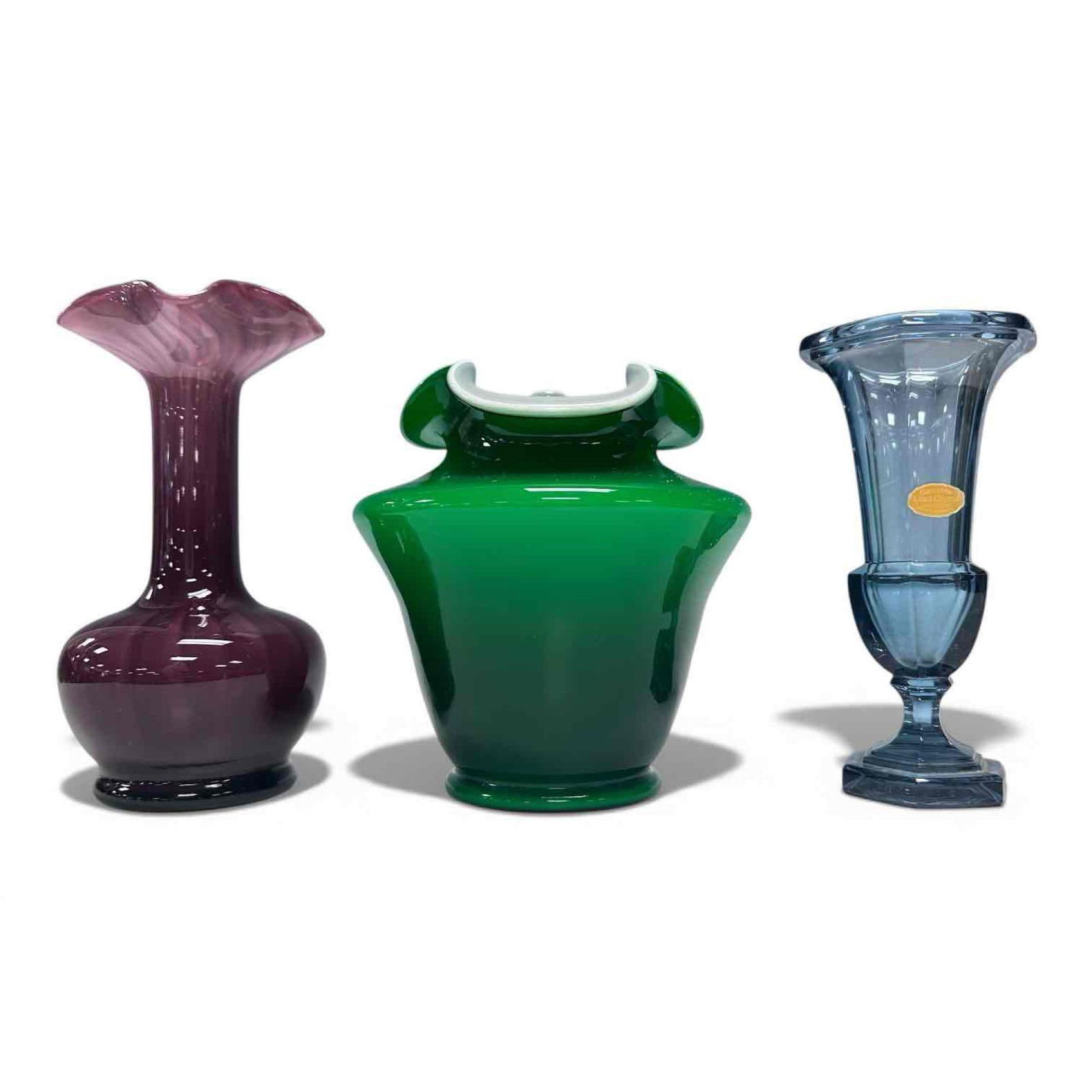 Art Glass and Crystal Vase Three Piece Grouping (3): Amethyst Italian ruffled top bulbous base with optic swirl pattern vase 9" tall, Fenton green ivy ruffled hand-blown vase with white interior 7.5" tall and German blue crystal trumpet vase 8" tall. In