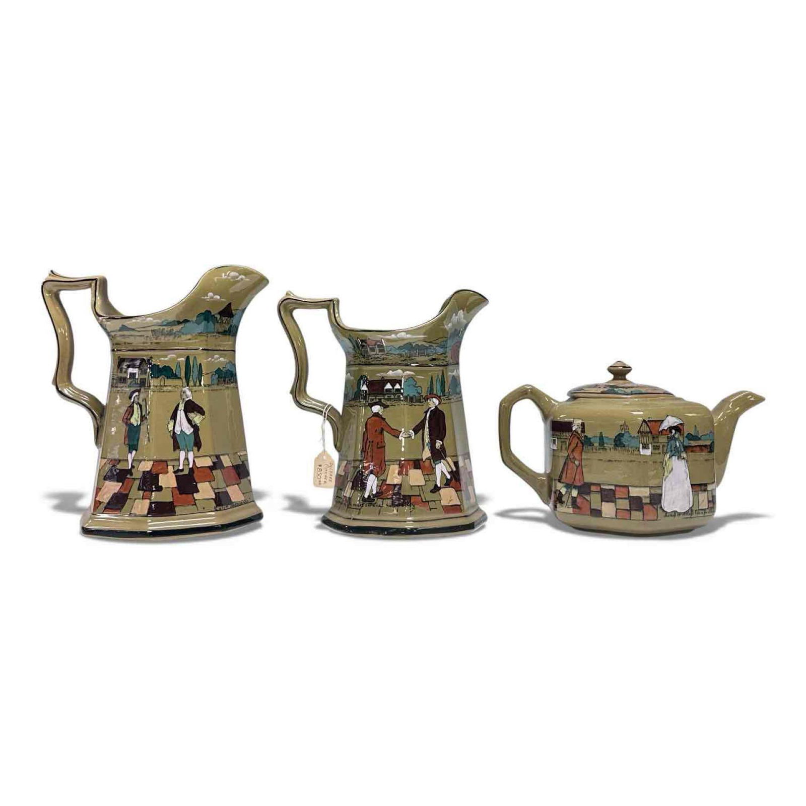 Buffalo Pottery Deldareware Pitchers and Teapot (3): Buffalo Pottery Deldware pitcher reading "This amazed me" depicting 19th century gentlemen village scene on a moss green background 9" tall, second pitcher reading "Welcomed me with most cordial hospi