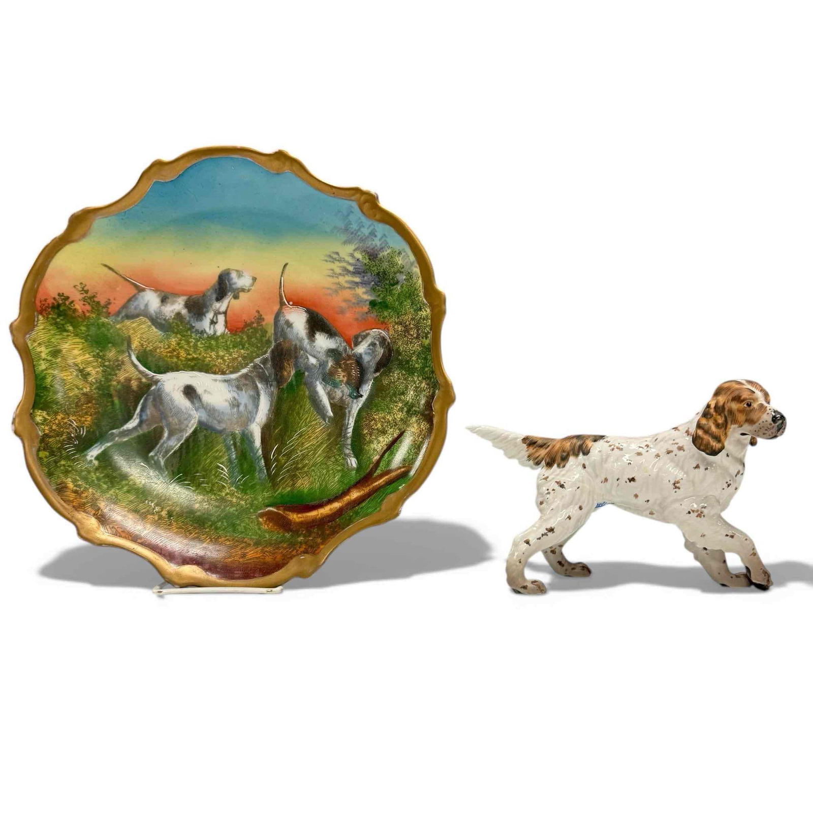 Carlsbad Austria Hunting Dog Lot: Carlsbad Austria Victoria porcelain plate with hunt dog landscape scene and scalloped rim, Measures approx 12". Also included in lot is 6"x 8" C. Martinu English Setter Figurine in good condition with