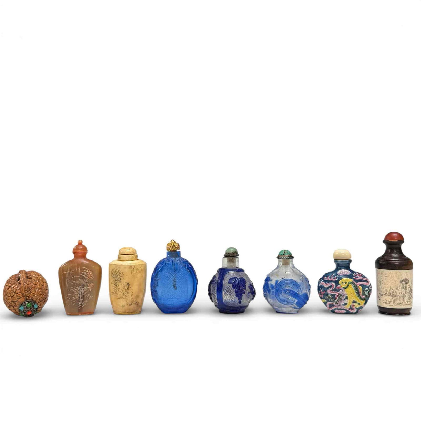 Snuff Bottles Collection Various Forms and Materials (8): Variety of vintage snuff bottle including; porcelain foo dogs, wood and bone, cobalt blue glass, "Thousand Monks" carved walnut, bone and carved stone. Depicting, people, birds, elephants, foliage and
