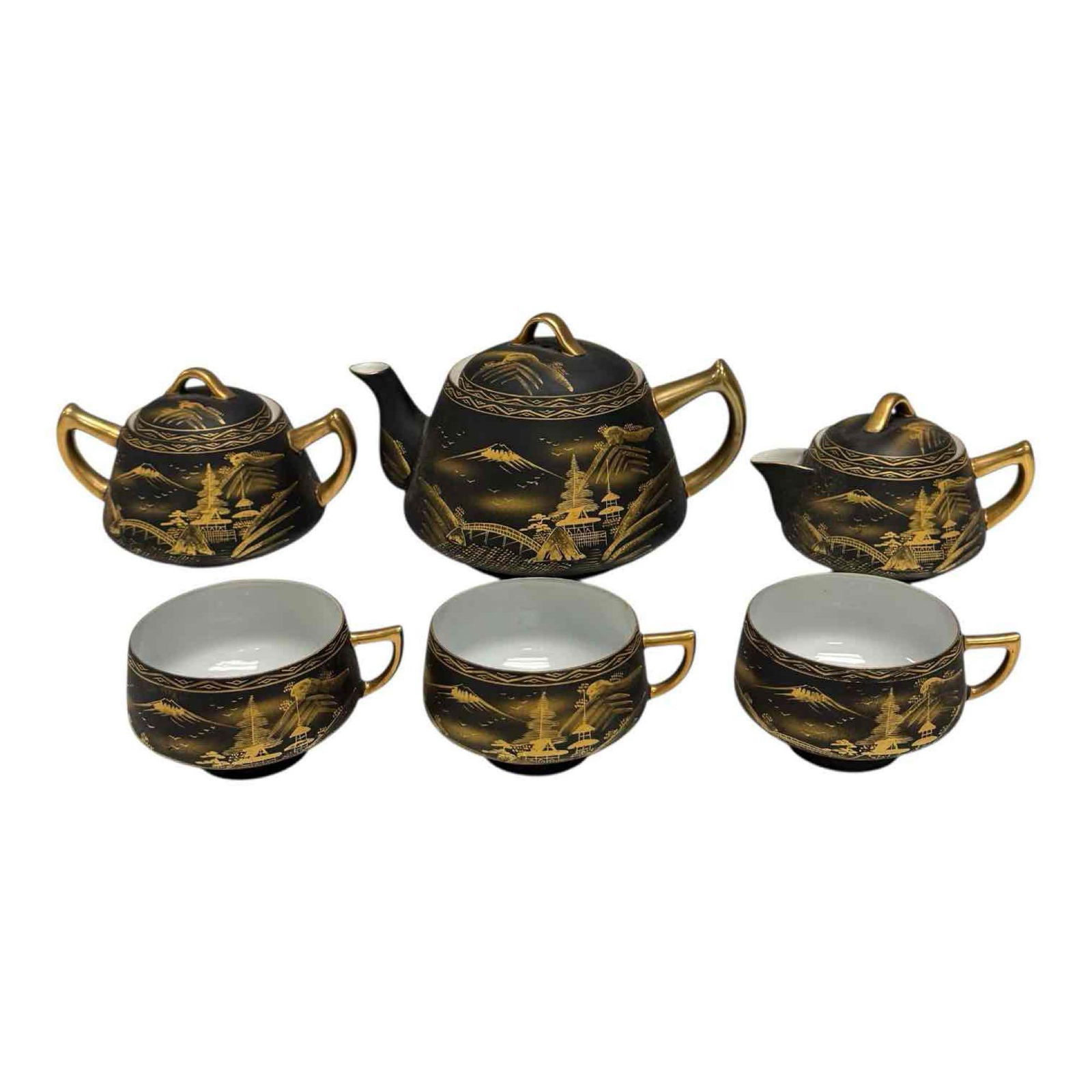 Koshida Japanese Matte Black Hand Painted Gold Landscape Tea Set (6): Vintage Koshida matte glaze tea service for three including creamer and sugar bowl. Hand painted in gold depicting mountains, pagodas and bridge landscape. Teapot measuring 5" tall. In good condition