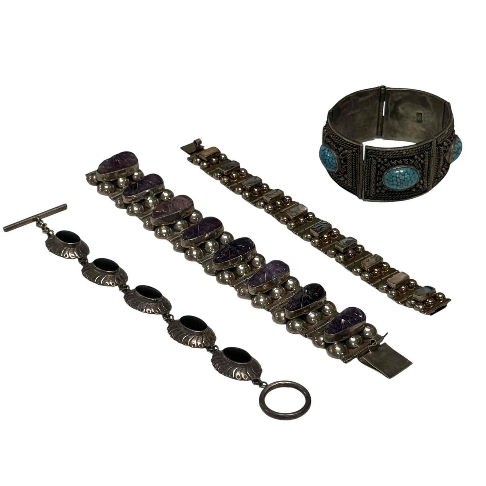 Sterling Silver, Filigree and Black Onyx Panel Bracelets (4): Amethyst carved mask panel bracelet 8" long 66 grams, abalone shell inlay sterling silver bracelet 7" long 26 grams, black onyx toggle clasp bracelet 7" long not marked but likely sterling 26 grams an