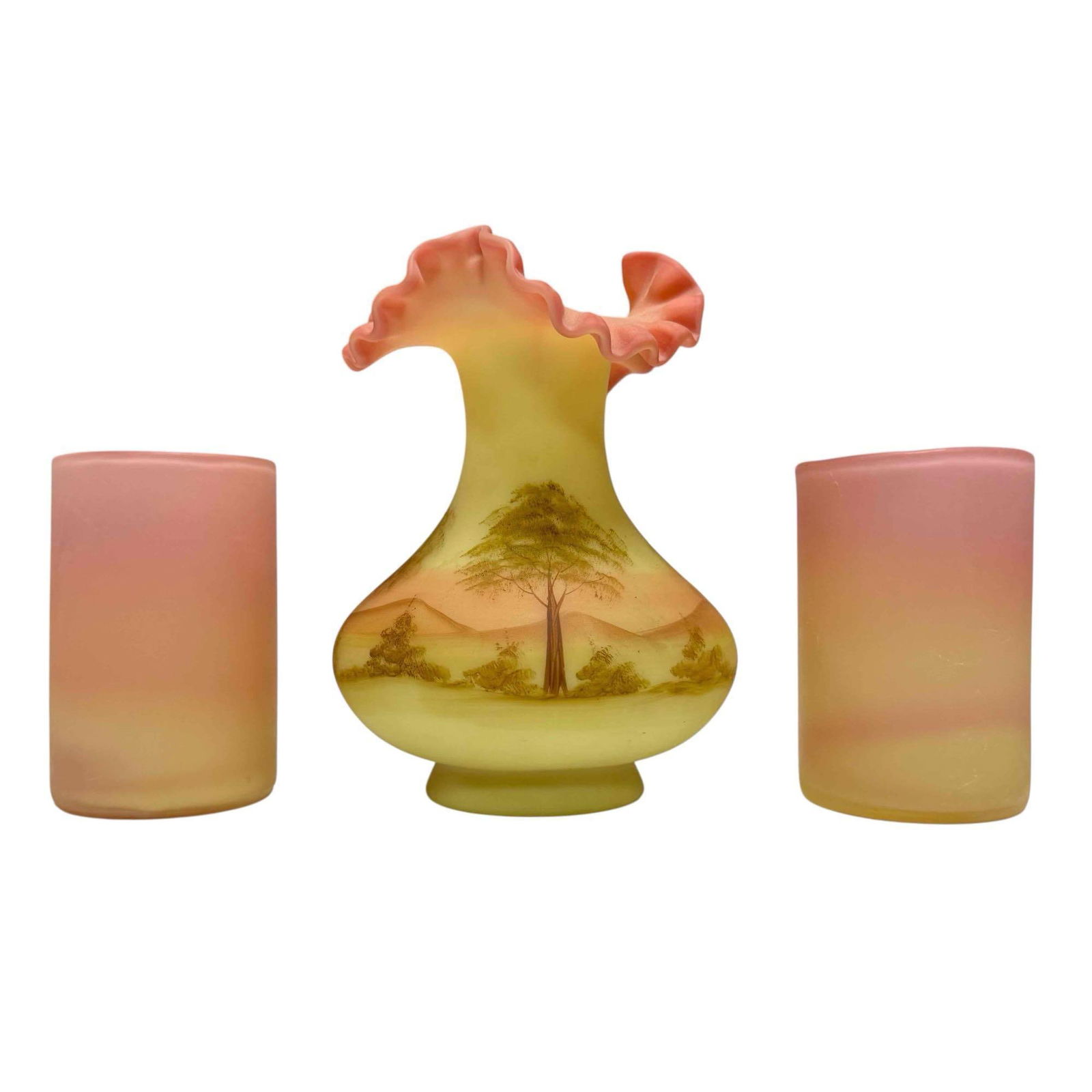 Fenton Painted Burmese Uranium Glass by Gloria Finn / Peachblow: A ruffled top scenic country landscape Fenton vase measuring approx 7" h x 5" diam and two satin finish peach blow tumbler glasses approx 4.5" h x 2.5" diameter. All in good condition, no issues, see