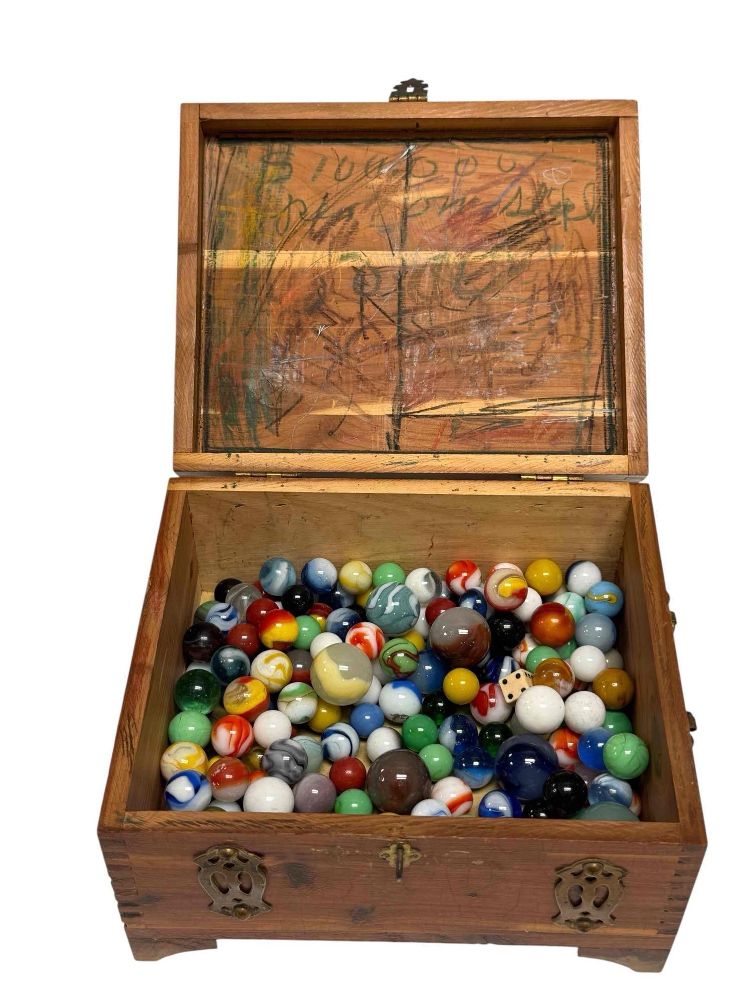 Collection of Vintage Glass Marbles in Wooden Case: Collection of vintage glass swirl marbles in various sizes and colors measuring approx. .25" to 1" diameter. In handled inlaid wooden box with brass bindings 4.5" tall by 8" wide. See photos for condi