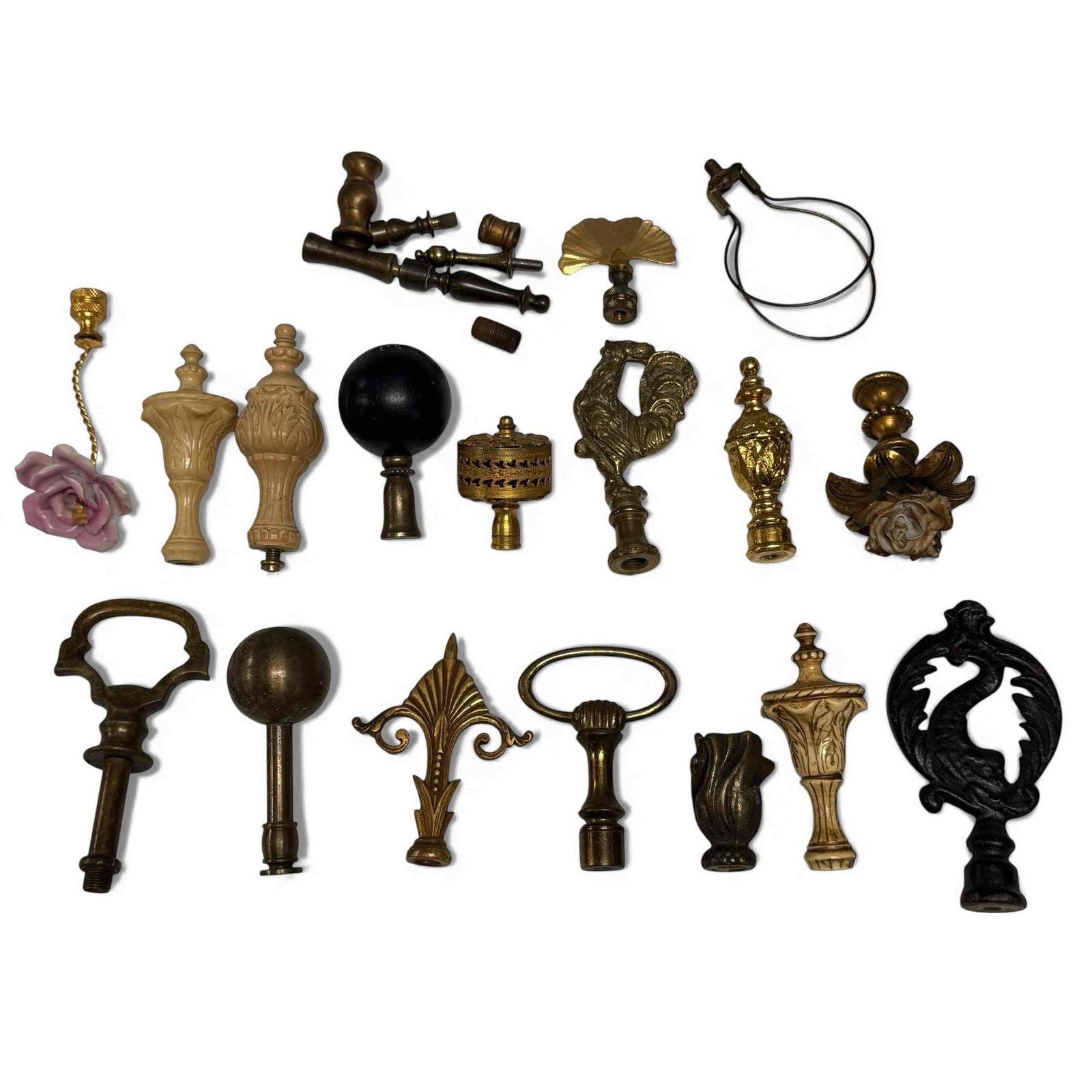 Large Collection of Lamp Finials: Collection of over 18 various shapes, sizes, and materials of spare lamp finials. Brass, metal, wood, Bakelite, cast, and porcelain. Floral, key, spindle, knob styles and more. See photos for conditio