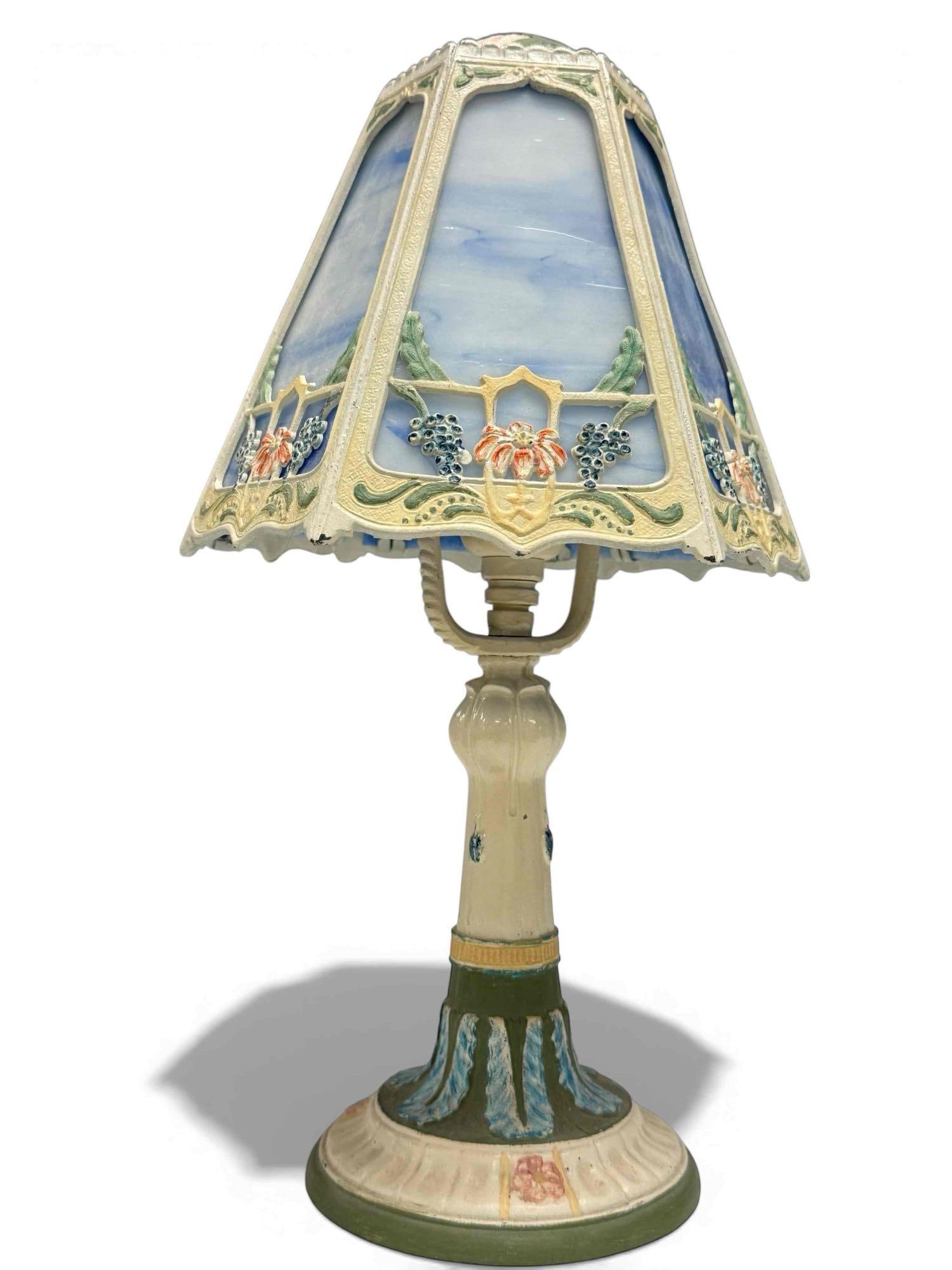 Art Nouveau Hand-Painted Slag Glass Table Lamp: Well done hand painted cast Art Nouveau table lamp. Shade of 6 blue slag glass panels with floral and grape accents. Measures approx 15" tall over all while shade measures 7" tall by 8.5" wide. Great
