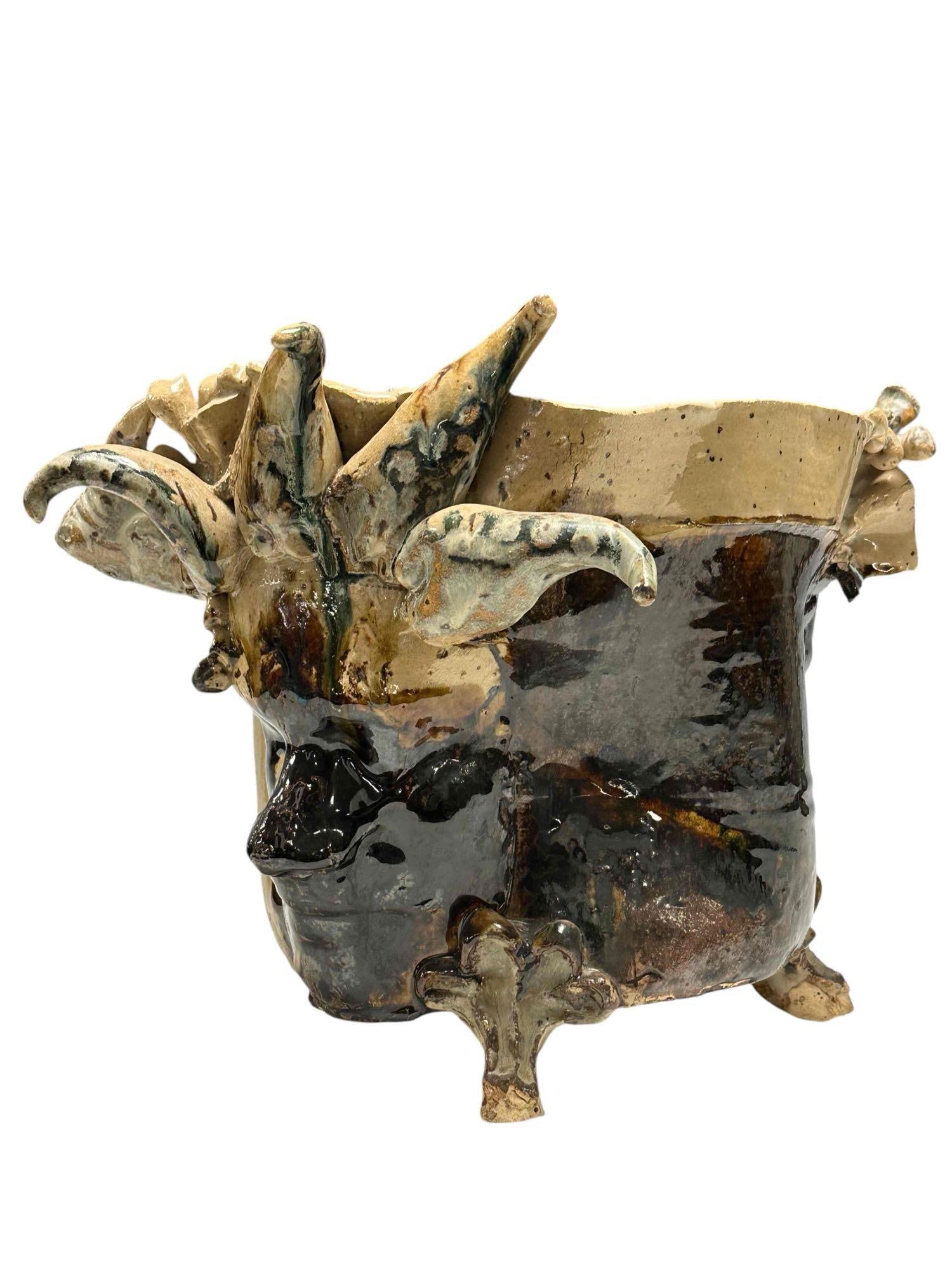 Glazed Stoneware Vessel "Faces" Lust Pottery: Very unusually conversation piece Lust Pottery stoneware jardiniere planter. A bit dark depicting molded straight lipped faces on either side with one having horn and a rhinoceros protruding from from
