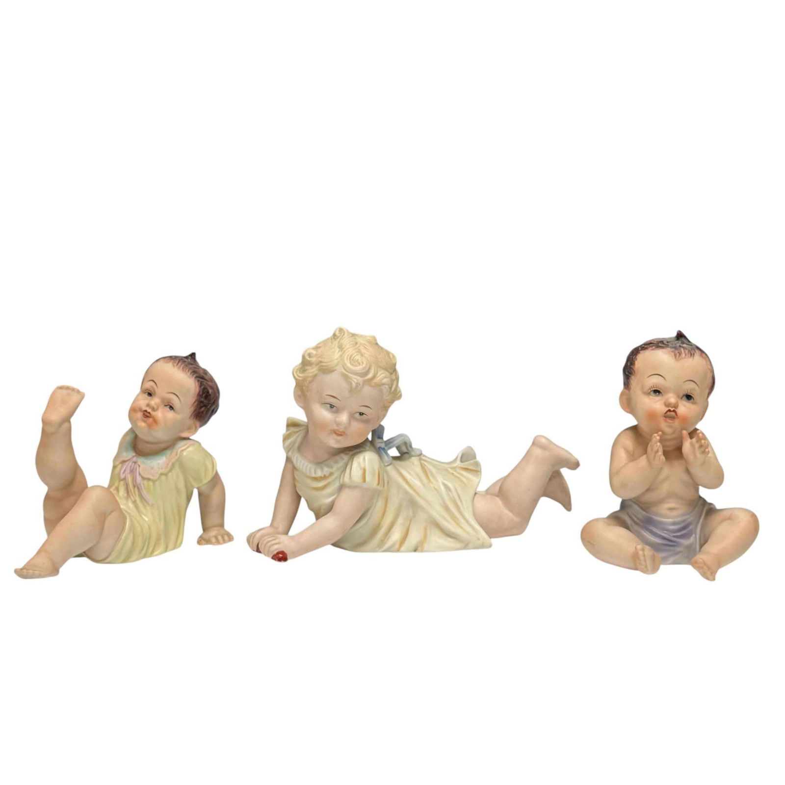 Three Porcelain "Piano Babies" Figurines (3): Three vintage porcelain "Piano Babies" figurines. Name comes from their original use as decorative items placed on top of grand pianos. Measuring approx. 5.25" to 6.5" tall. In good condition with no