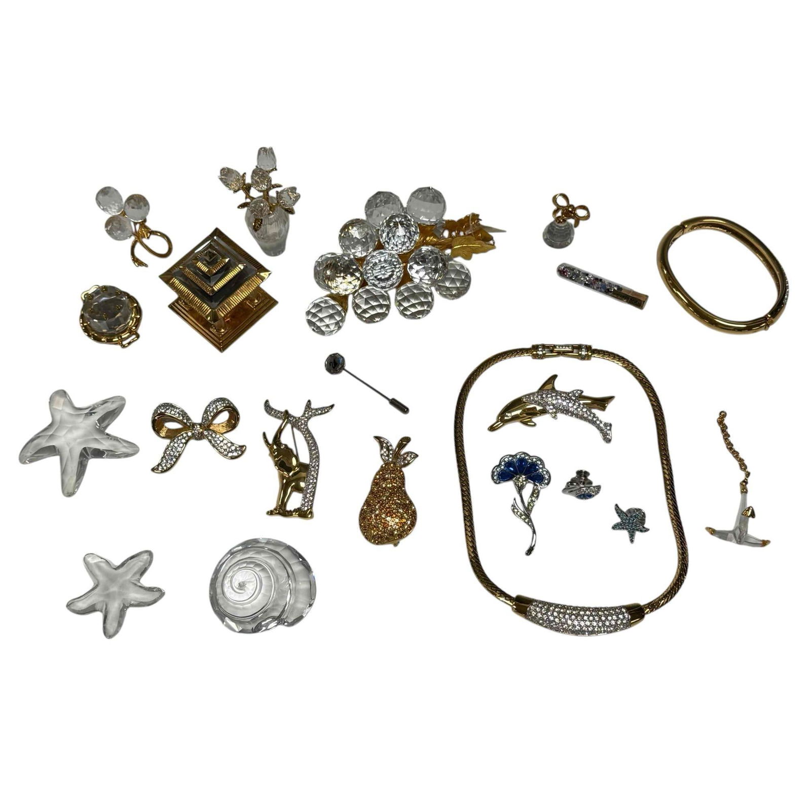 Collection of Swarovski Crystal Jewelry and Figurines: Swarovski crystal jewelry and figurines including' "Sparkling Fruit" grape cluster 4.25" long, pear, dolphins, elephant, bow and pear brooches, necklace 15.5" long, bangle bracelet, pagoda figurine 2"