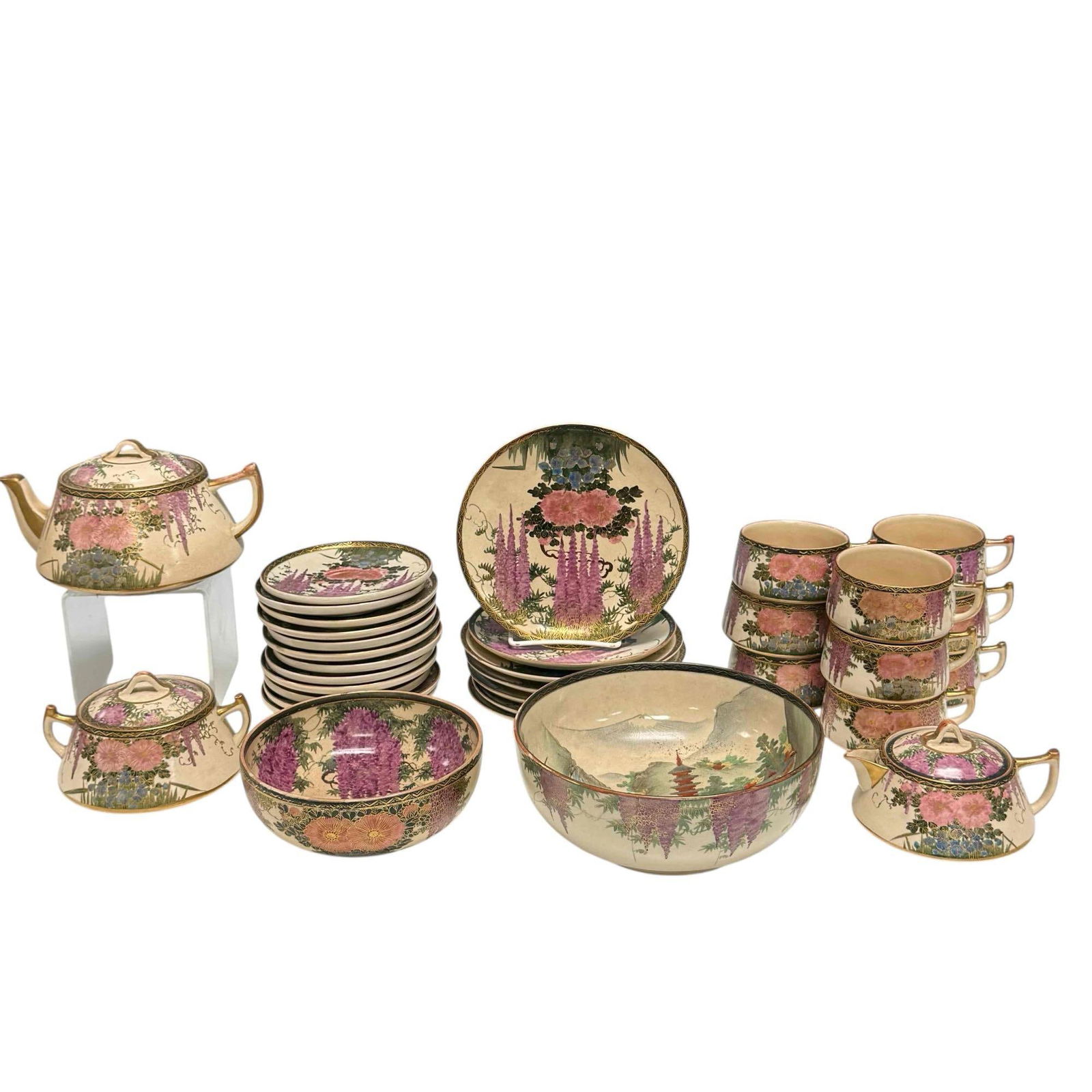 Late 19th Early 20th Century Japanese Satsuma Tea Service: Hand painted Japanese Satsuma porcelain tea in traditional wisteria scenes. Including; teapot 4" tall, lidded cream and sugars 3.25" tall, nine cups 2" tall, twelve saucers 5.25" diameter with half ve