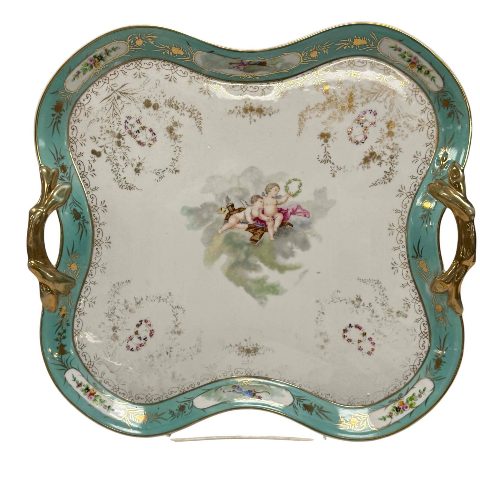 20th C. Porcelain Dessert Tray with Cherubs: Mint green edge border, gold gilt double handles and scalloped formed. Surface wear to gold gilt as shown, otherwise very good, see photos. Measuring approx 15" w x 14" t x 1" h.