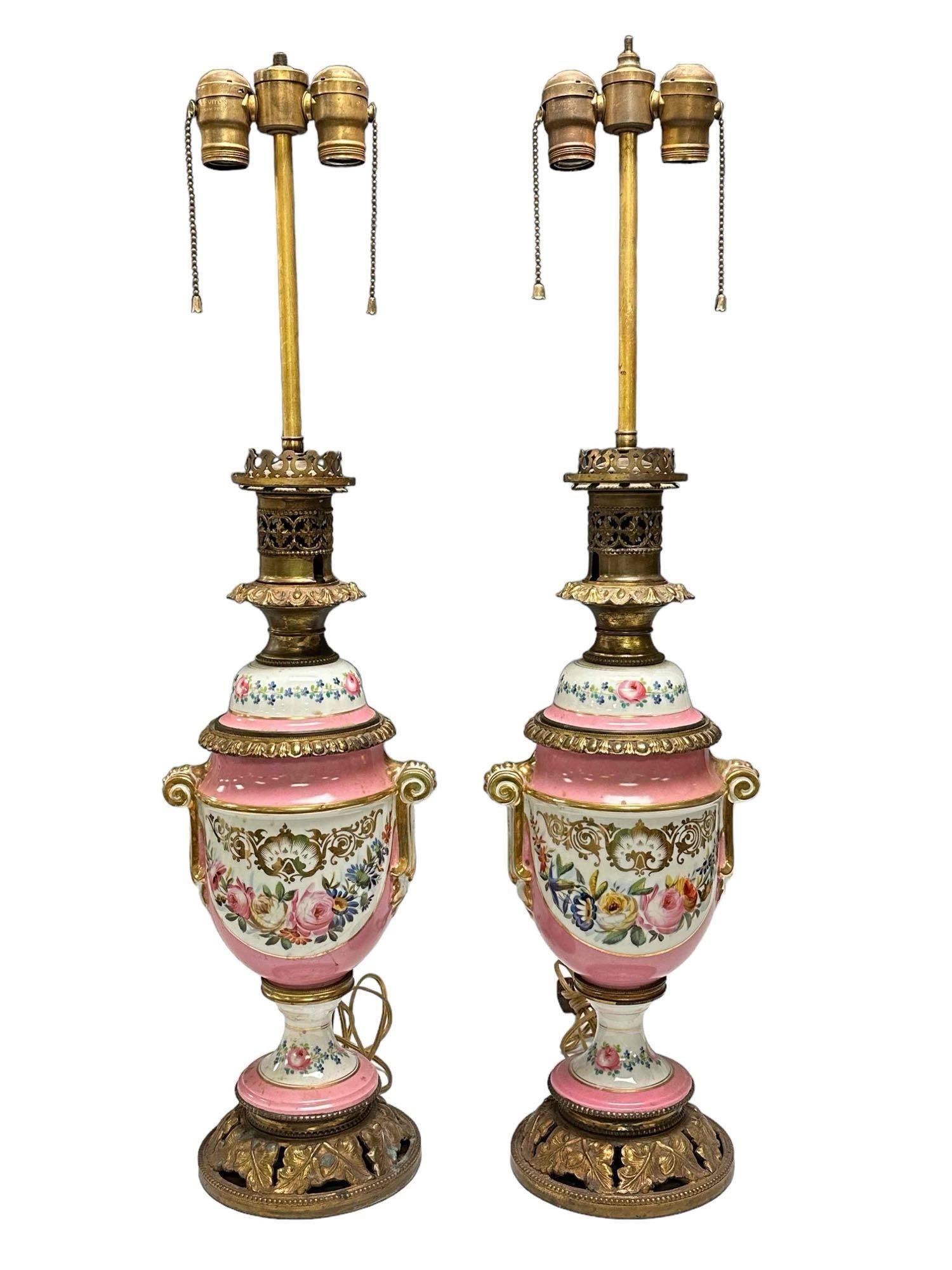Pair of French Urn Form Old Paris Lamps: Pair of French Porcelain lamps. Floral garland decorated with brass bases. measuring approx. 32" tall. Signs of use and wear as shown, see photos