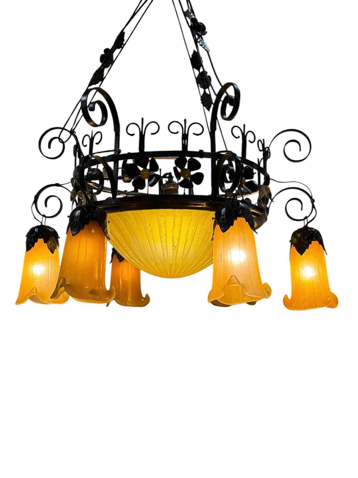 Art Nouveau Style Chandelier after Daum Nancy: Wrought iron and bent wire frame with yellow textured frosted glass. All with Daum Nancy raised stamped signatures as shown. Good working condition as shown. Measuring approx 36" h 28" x 28" diameter.
